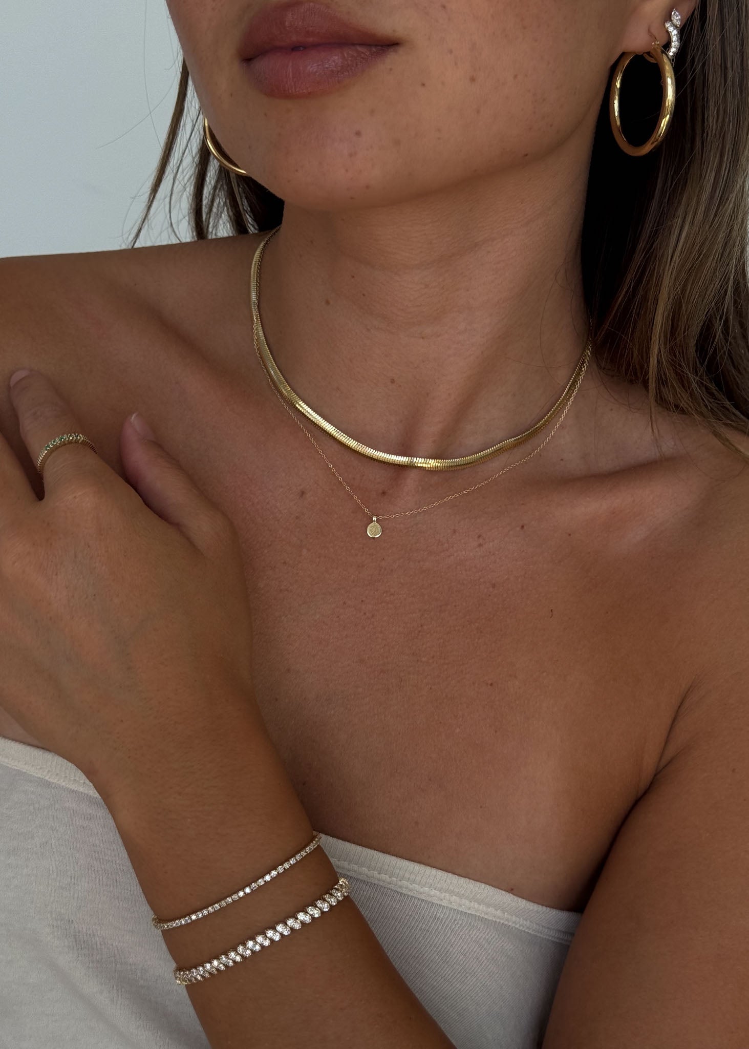 Model wearing Kinn Studio 14k gold classic hoop earrings