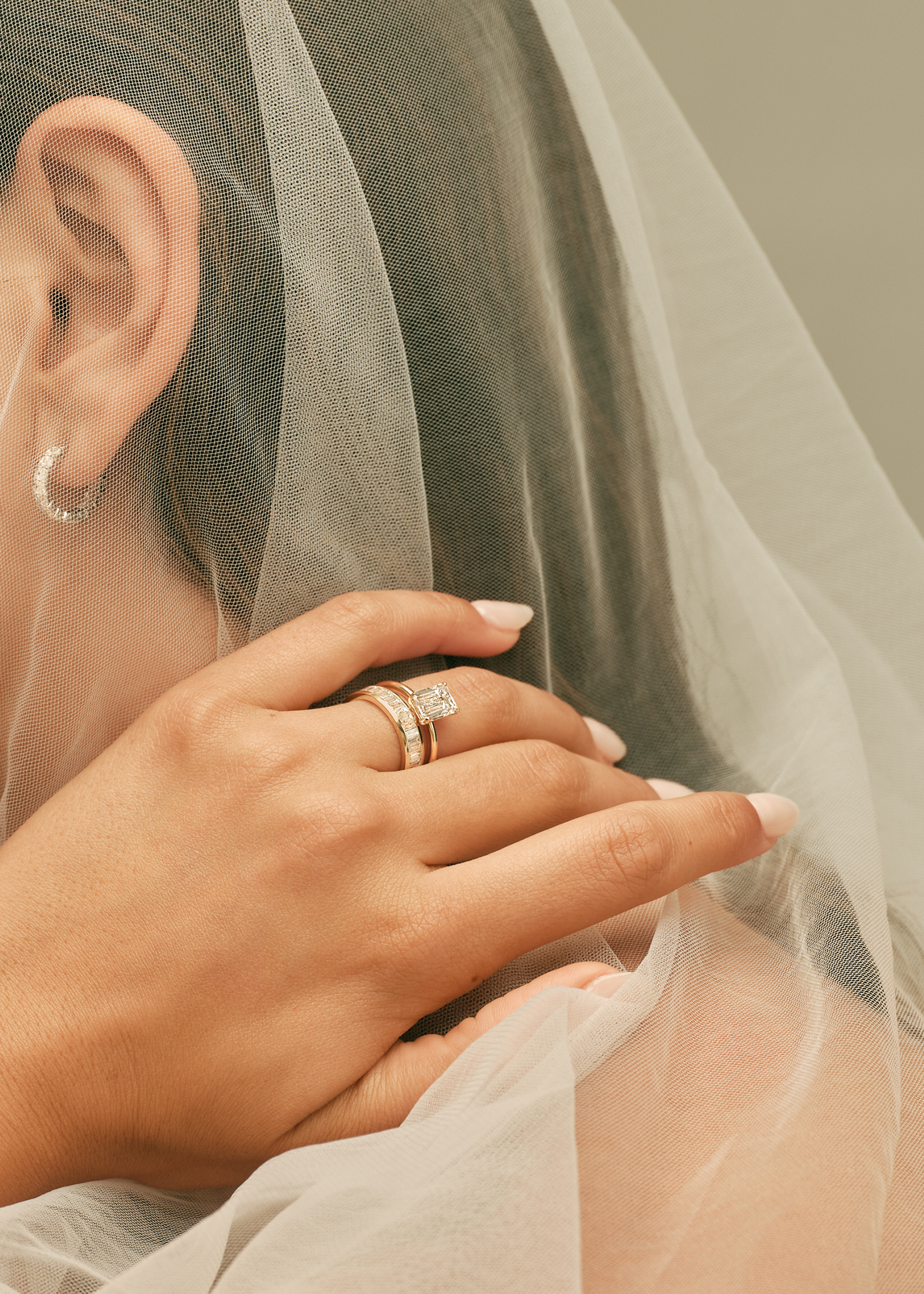 Close-up of a bride's hands with rings and a veil