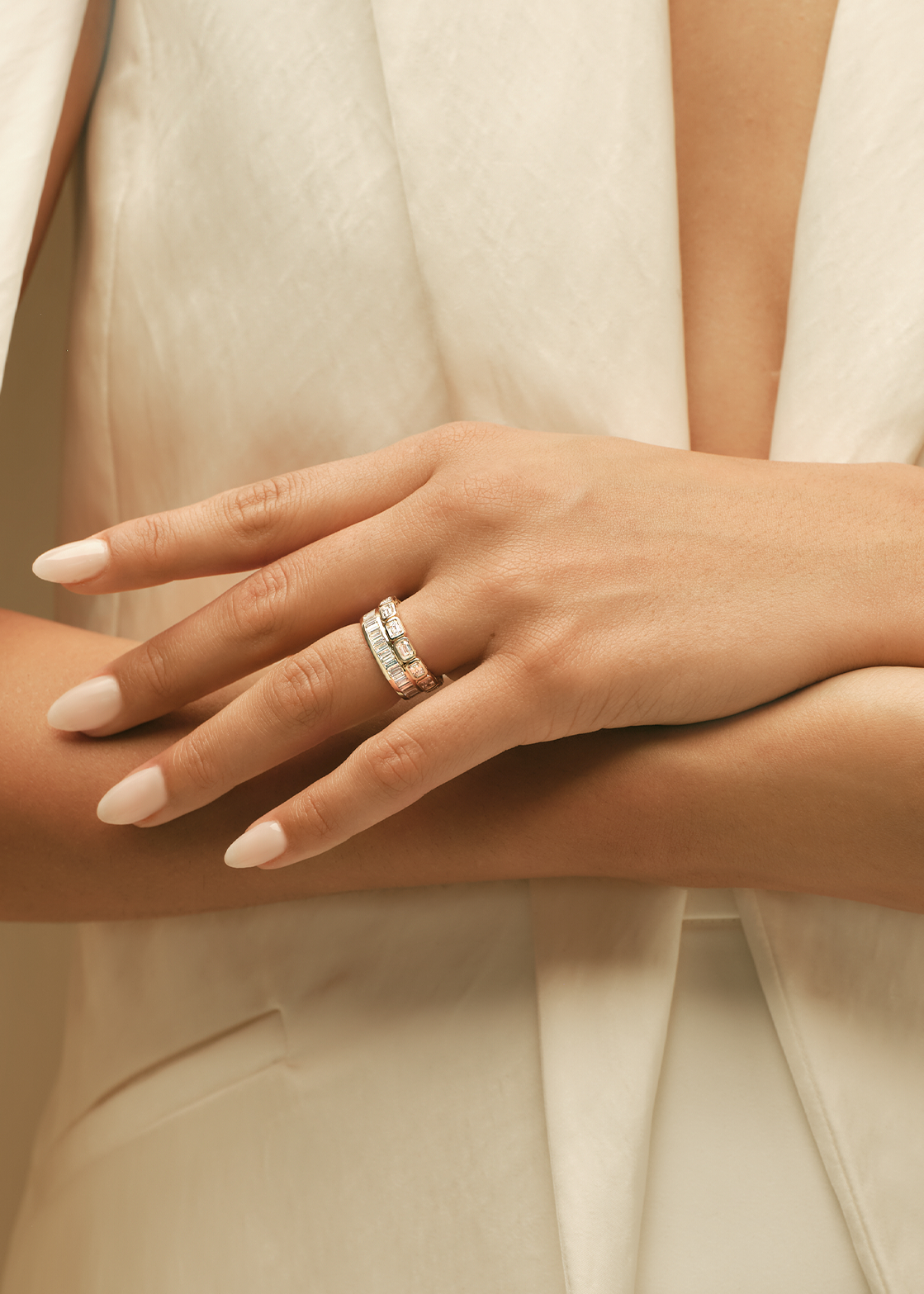 Close-up of a hand wearing a ring with a neutral background