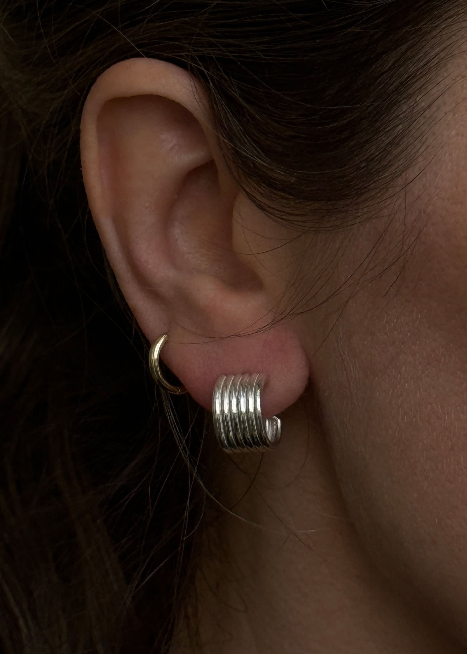 close up of a woman's ear wearing Kinn Studio 925 Sterling Silver Mercer Cuff Hoop Earrings