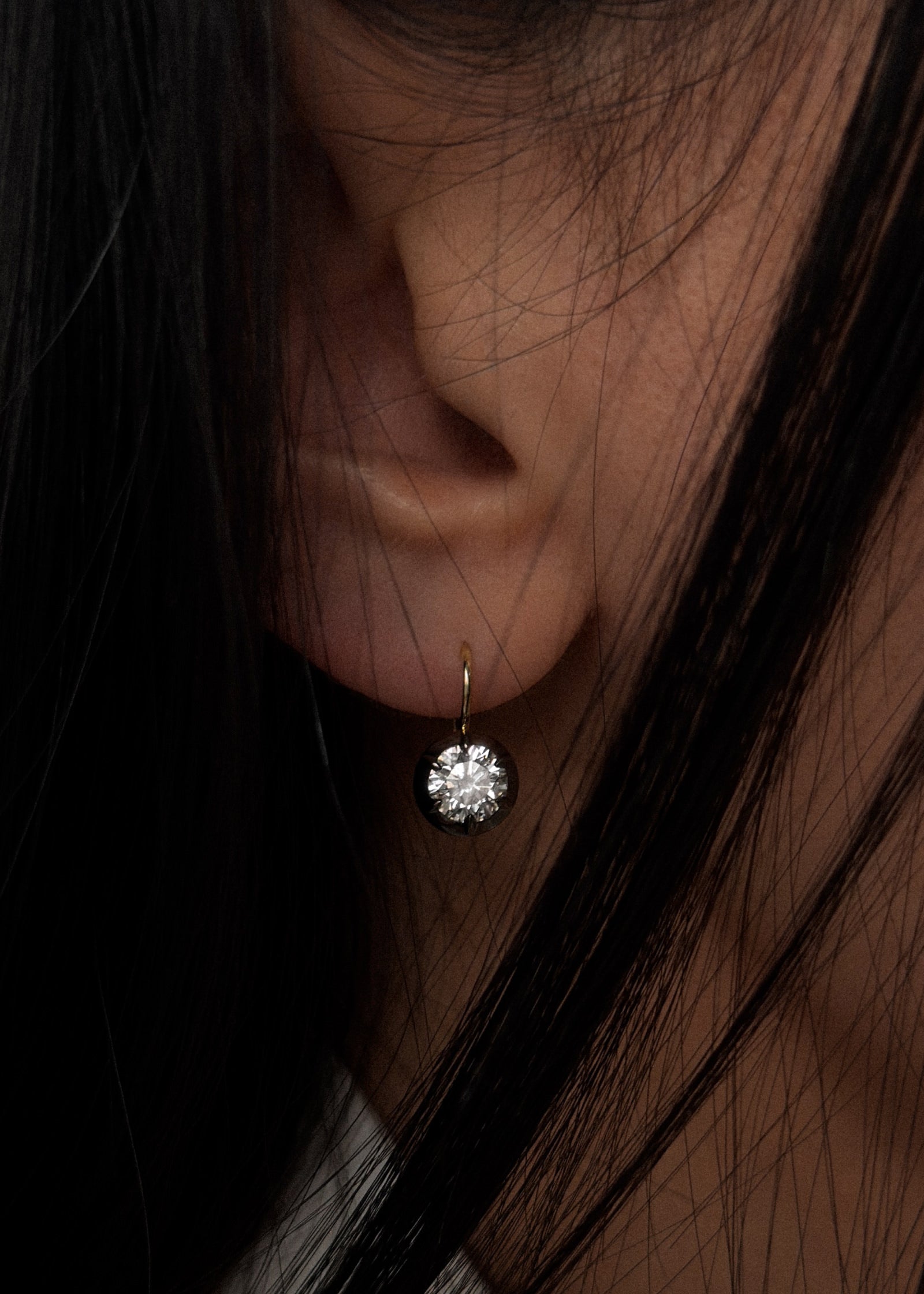 close up of a woman with dark hair wearing a Kinn 14k gold Rosette Black Rhodium Round Diamond Earring