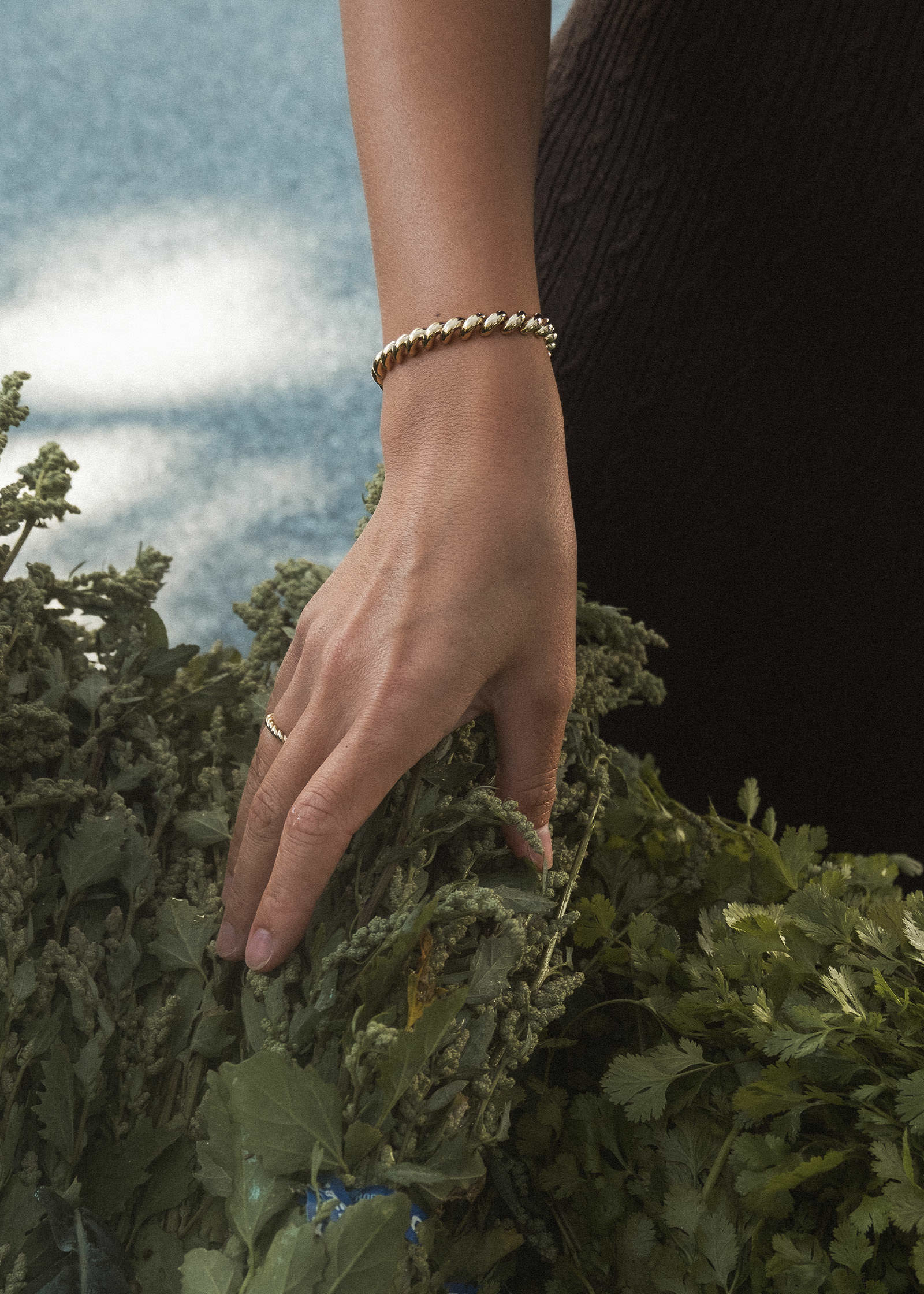 Duyen Ha at a farmers market wearing a Kinn Studio 14k Gold Hampshire House Bracelet