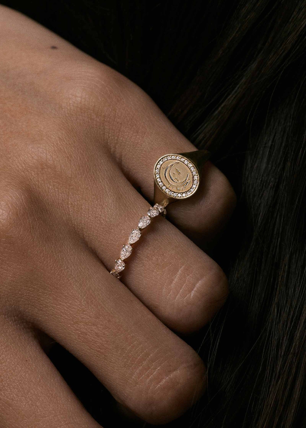 A close-up of a hand wearing a Kinn 14k Gold Crescent Dream Diamond Signet Ring