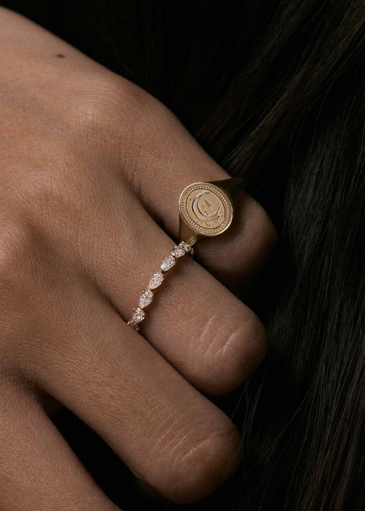 A close-up of a hand wearing a Kinn 14k Gold Crescent Dream Signet Ring