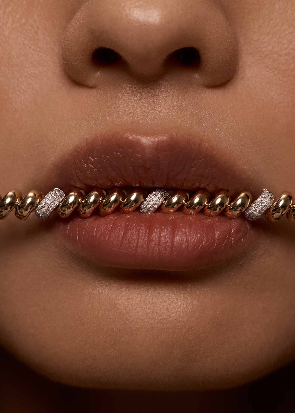 close up of a woman's mouth with a Kinn 14k Gold Pavé Diamond Petite Hampshire House Bracelet between her lips