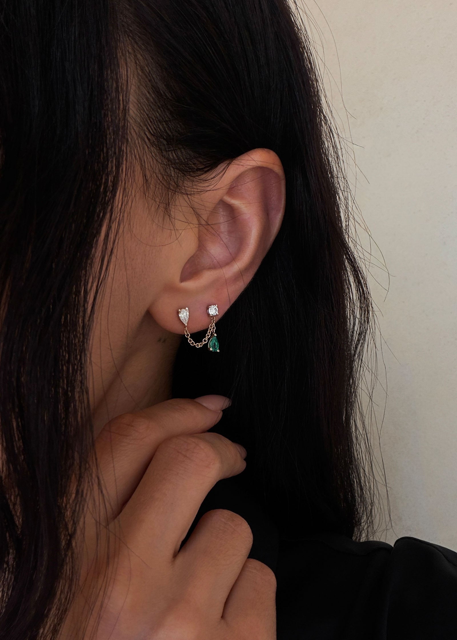 woman wearing a Kinn x Prince 14k Gold Doubles Diamond & Emerald Chain Earring