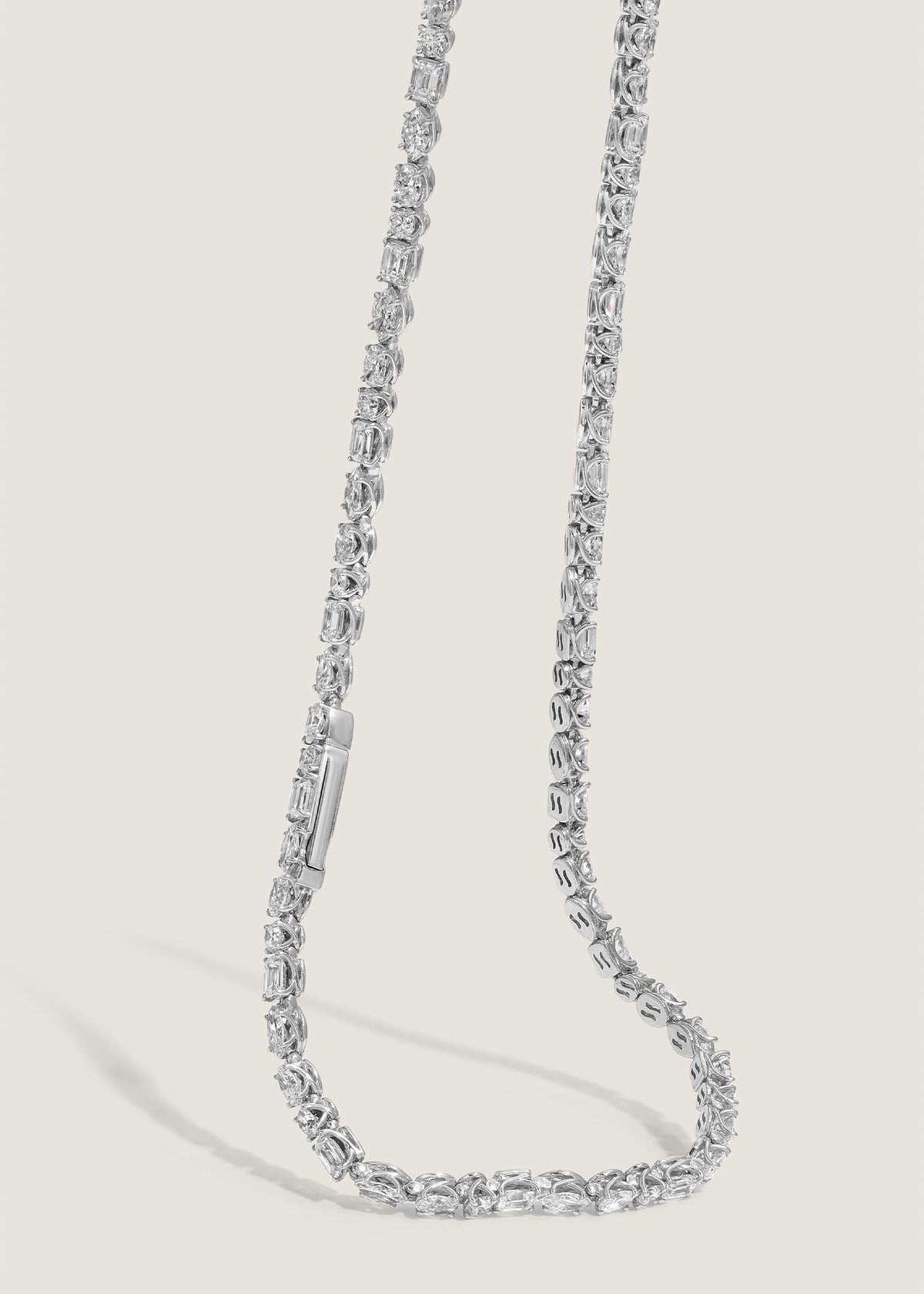 a Kinn 14k White Gold Esme Fancy Shape Diamond Tennis Necklace draped down showing the clasp