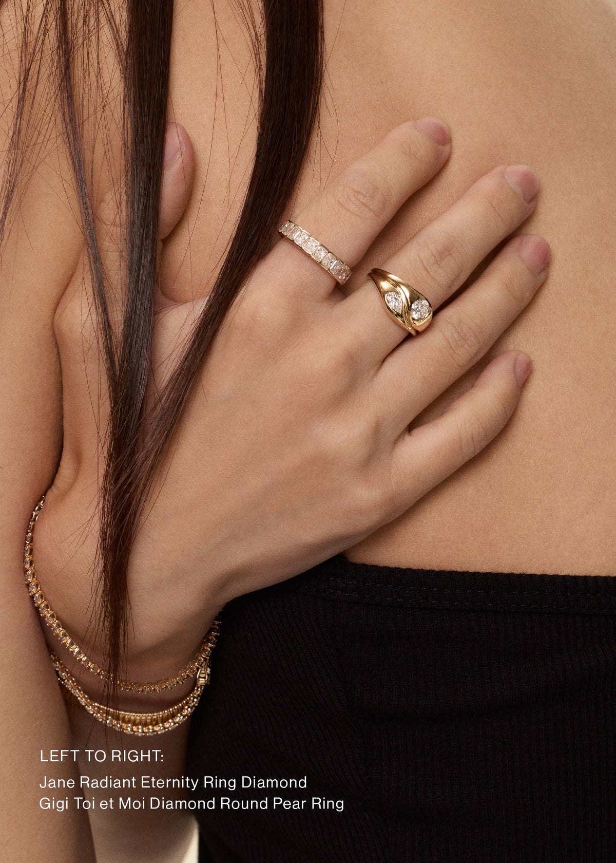 Close-up of a woman's hand and upper back wearing a Kinn 14k Gold Jane Radiant Diamond Eternity Band Ring with a Gigi Toi et Moi Ring. Text at the bottom identifies the rings.