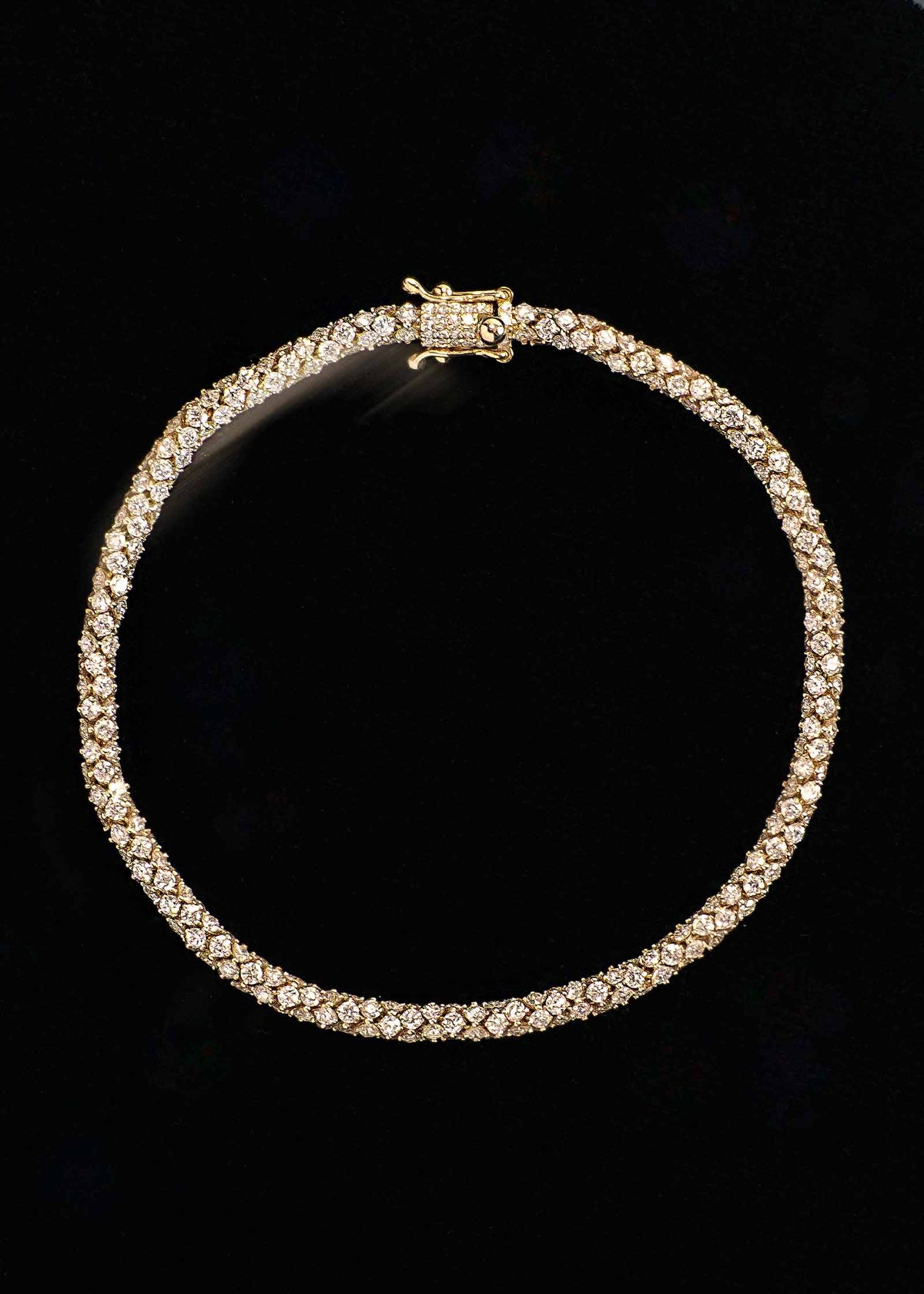 A Kinn 14k Gold Isadora Tubular Diamond Tennis Bracelet against a black background