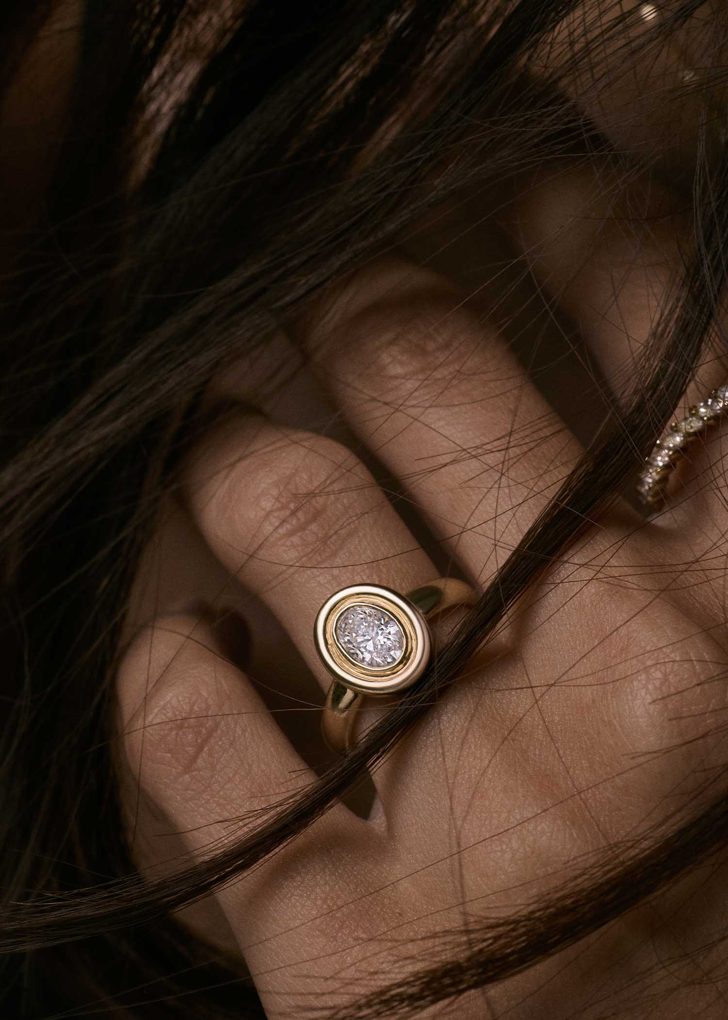 close up of woman's hand wearing a Kinn Studio 14k Gold The Jardin Diamond Engagement Ring