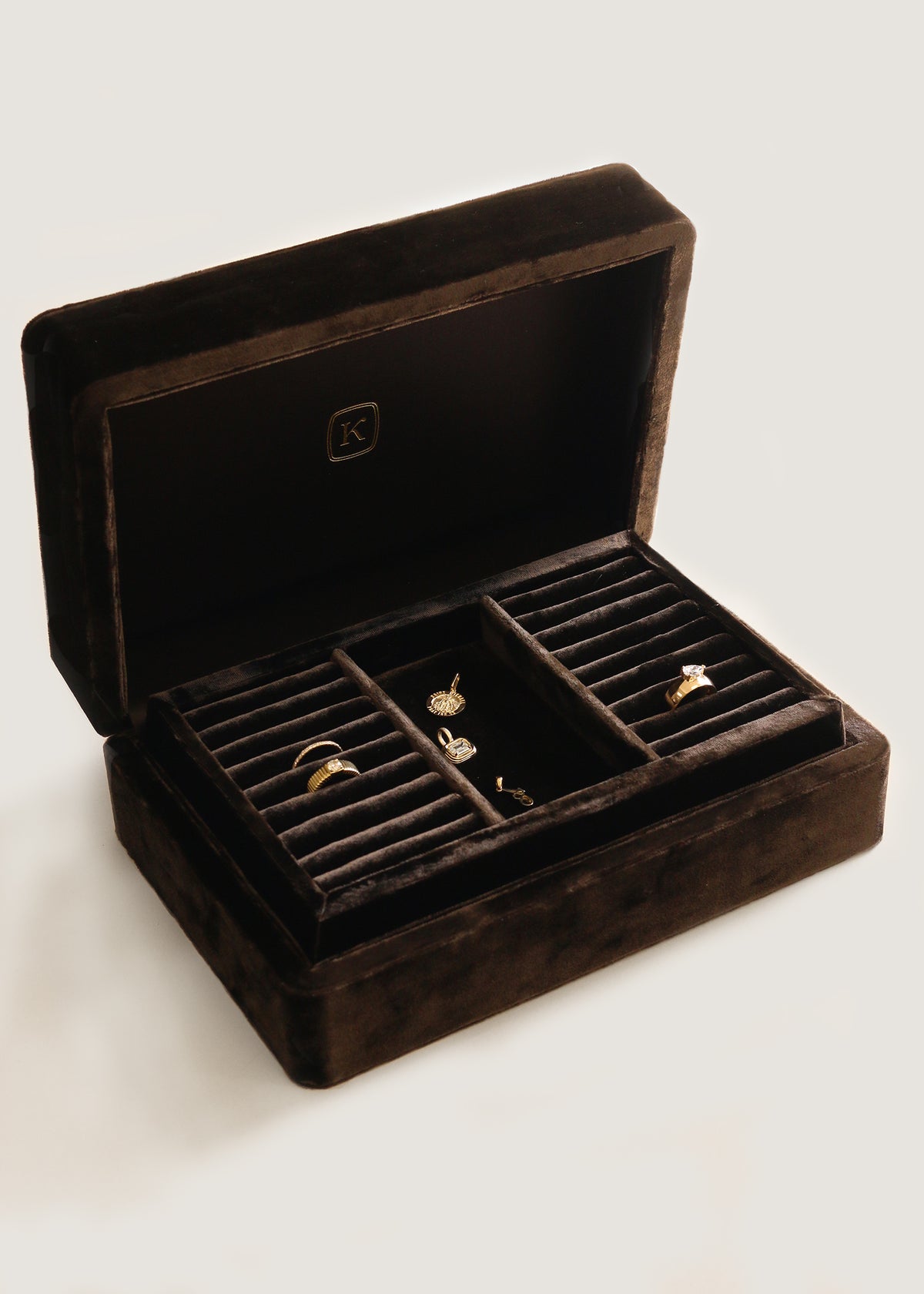 An open The Keepsake Jewelry Box by Kinn Studio with jewelry inside against an off-white background