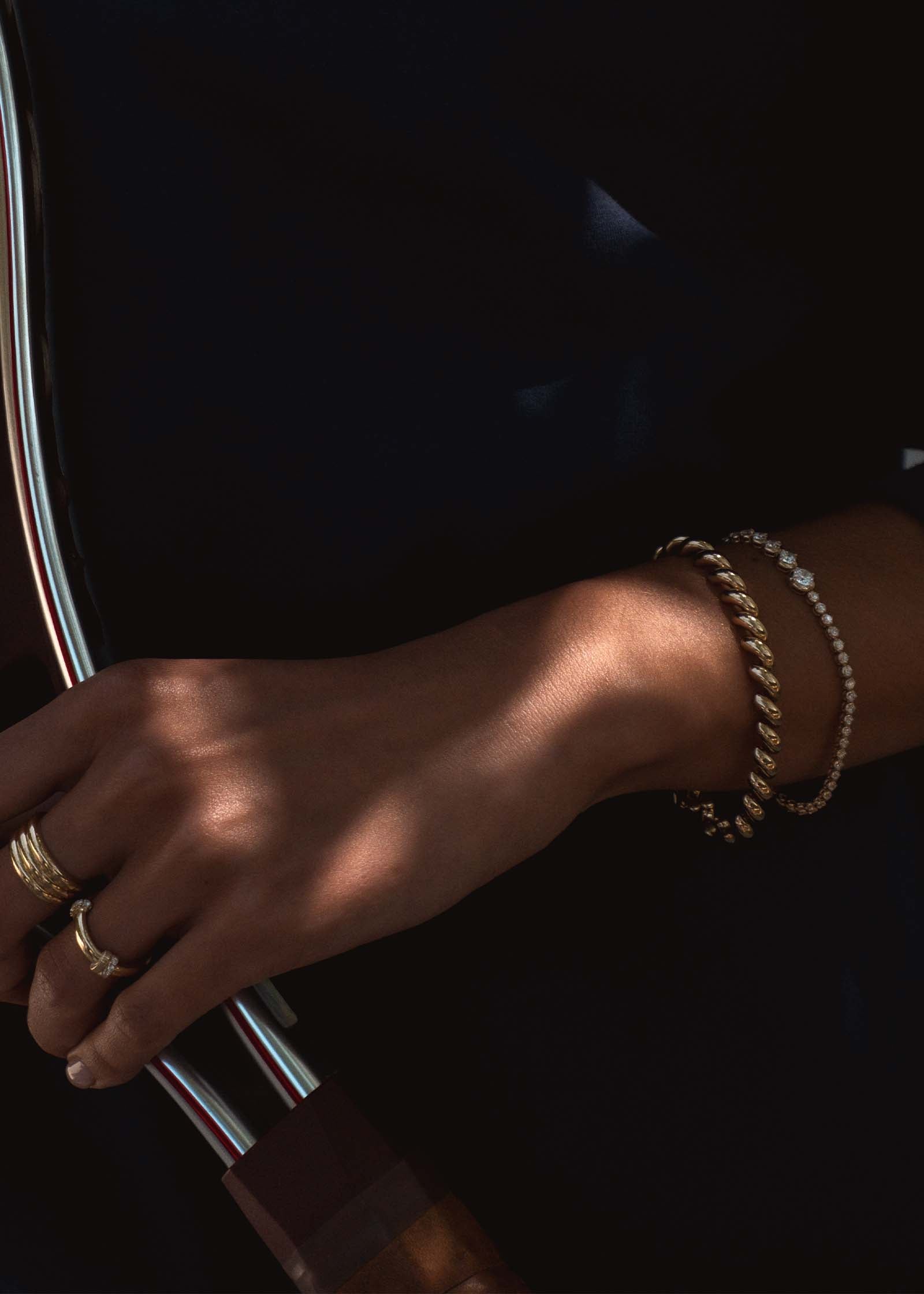 woman holding a tennis racquet wearing a Kinn x Prince 14k Gold Naomi Graduated Diamond Tennis Bracelet and Hampshire House bracelet stacked together on her wrist