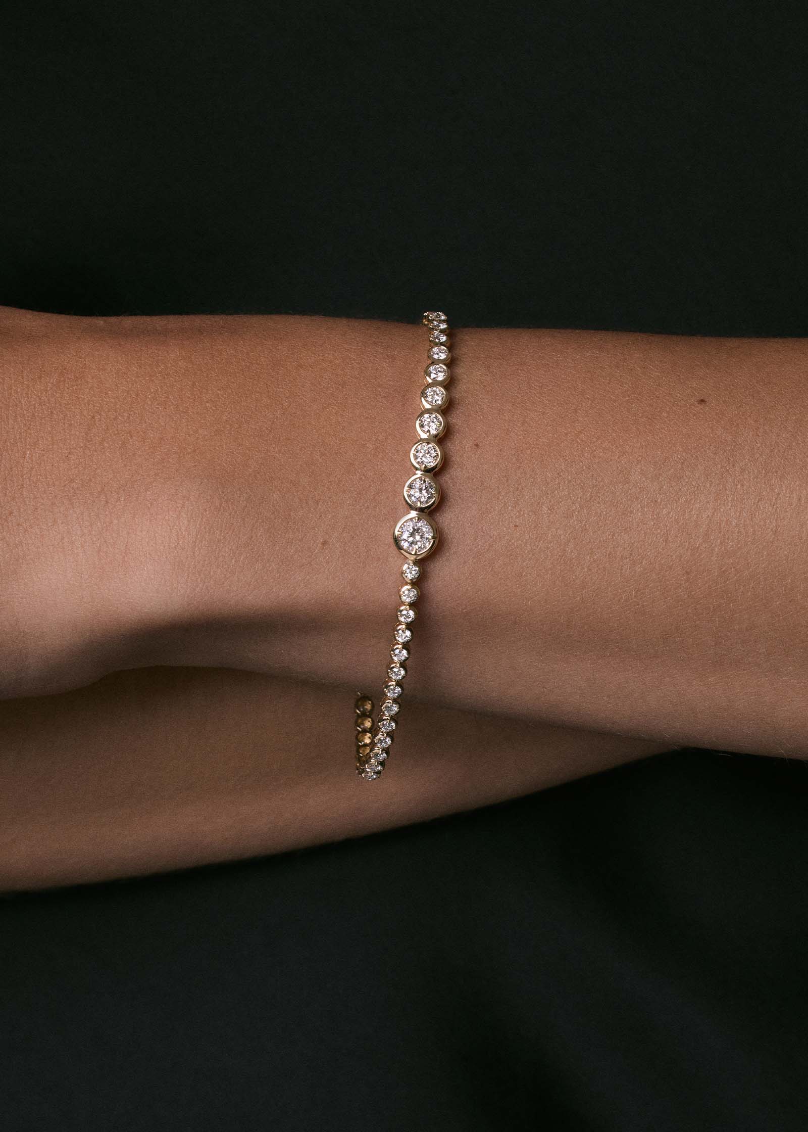 close up of a woman's wrist wearing a Kinn x Prince 14k Gold Naomi Graduated Diamond Tennis Bracelet