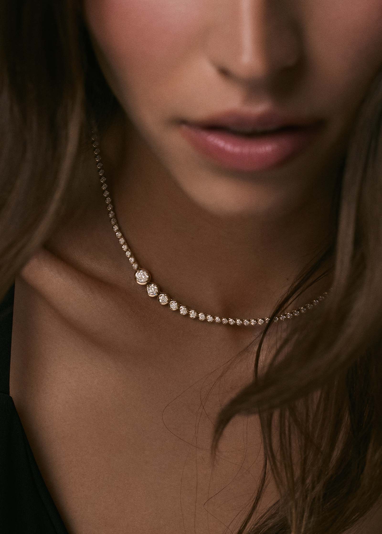 A close up of a woman wearing a Kinn x Prince 14k Gold Naomi Graduated Diamond Tennis Necklace