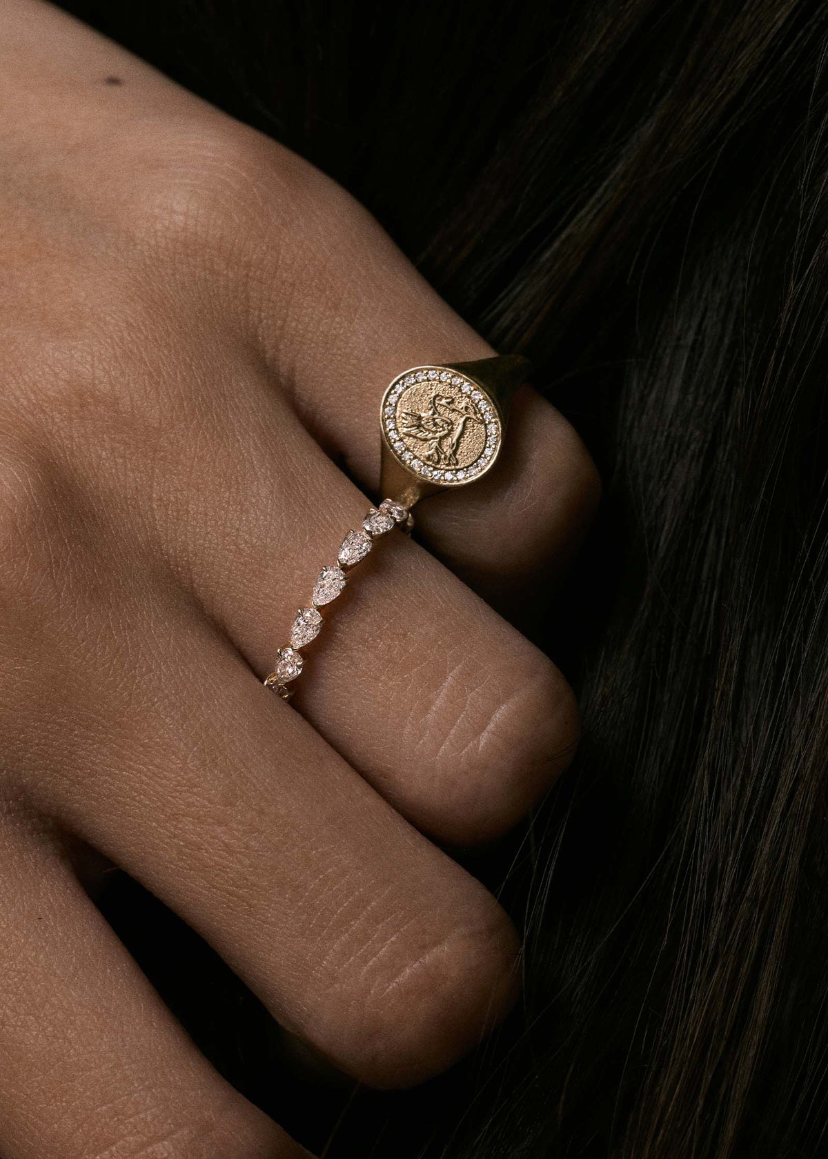 A close up of a Kinn 14k Gold Pegasus Dream Diamond Signet Ring on a pinky finger