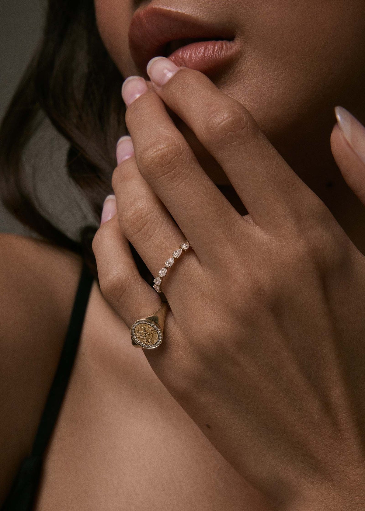 A woman wearing a Kinn 14k Gold Pegasus Dream Diamond Signet Ring on a pinky finger
