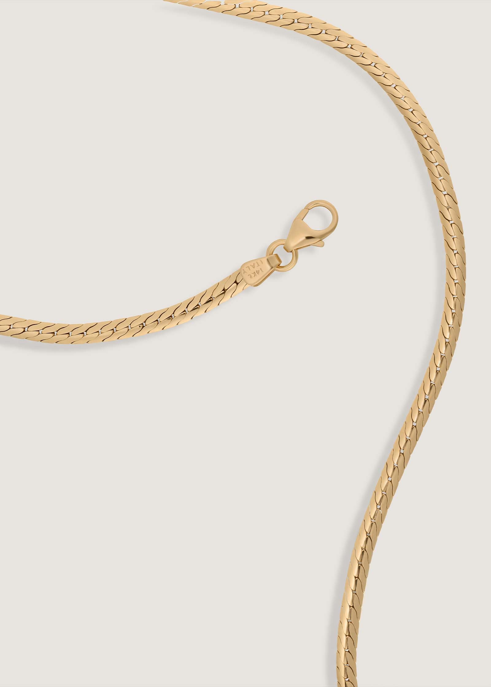 A Kinn 14k Gold Petite Kennedy Herringbone Chain Necklace laid flat showing the lobster clasp closure and Italian 14k gold mark
