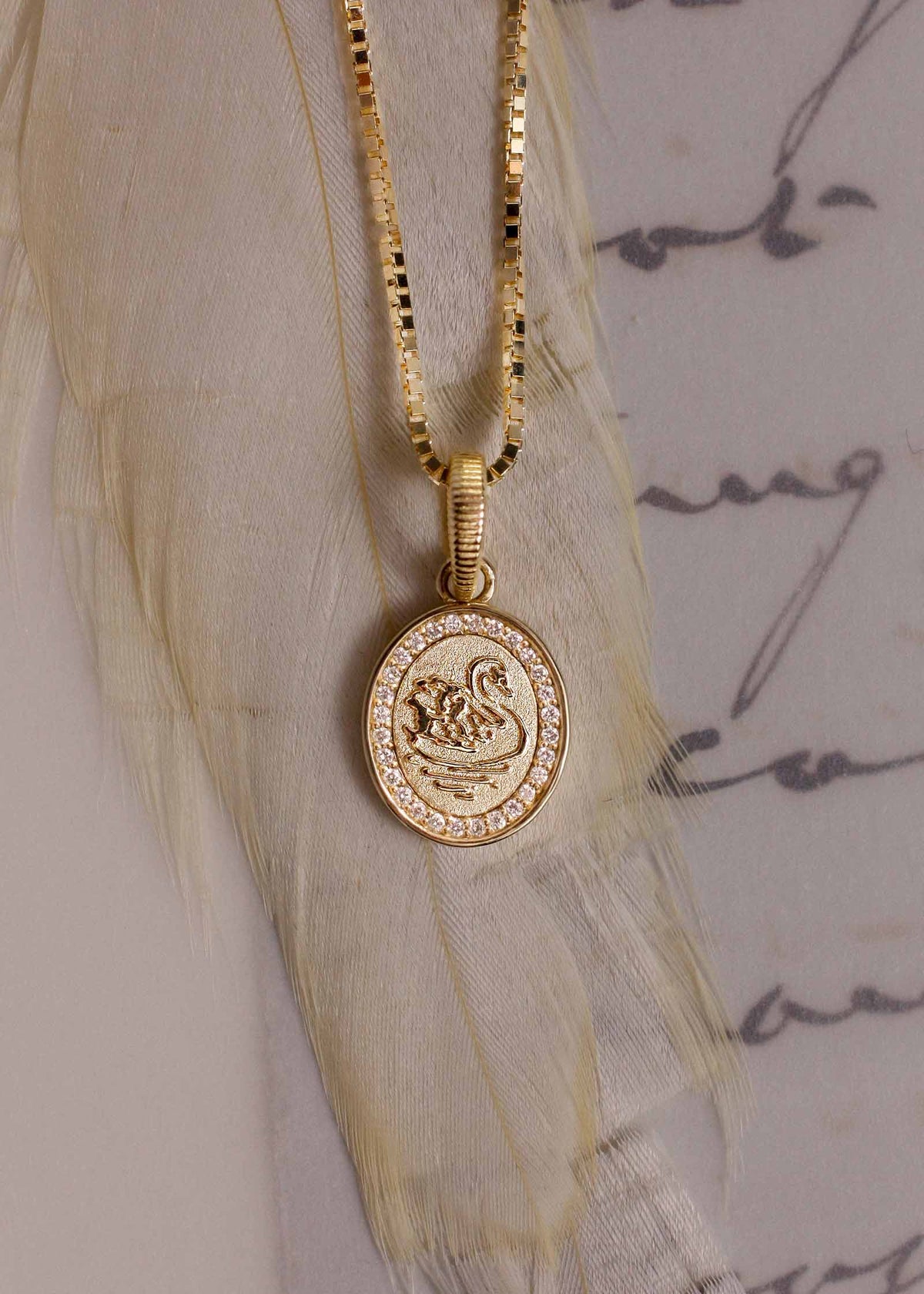 A Kinn 14k Gold Swan Dream Diamond Pendant on a box chain necklace