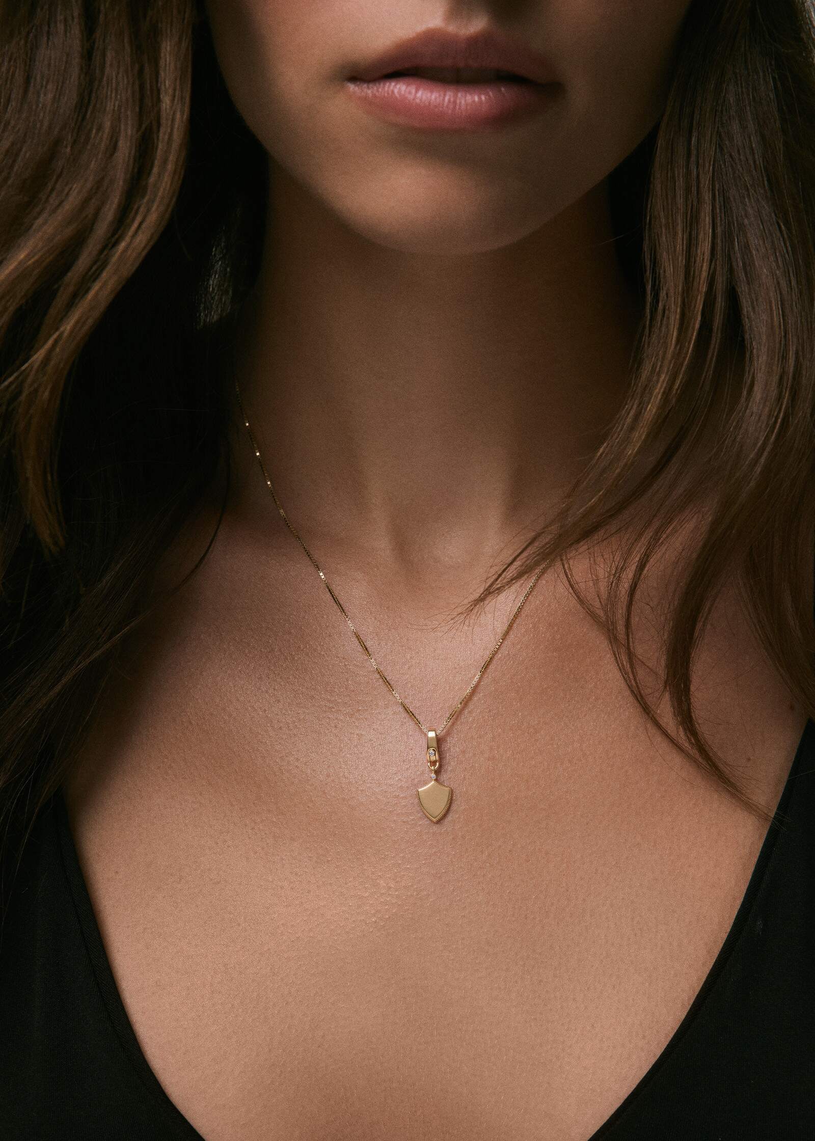 woman wearing a Kinn 14k Gold Ace Shield Diamond Pendant Necklace