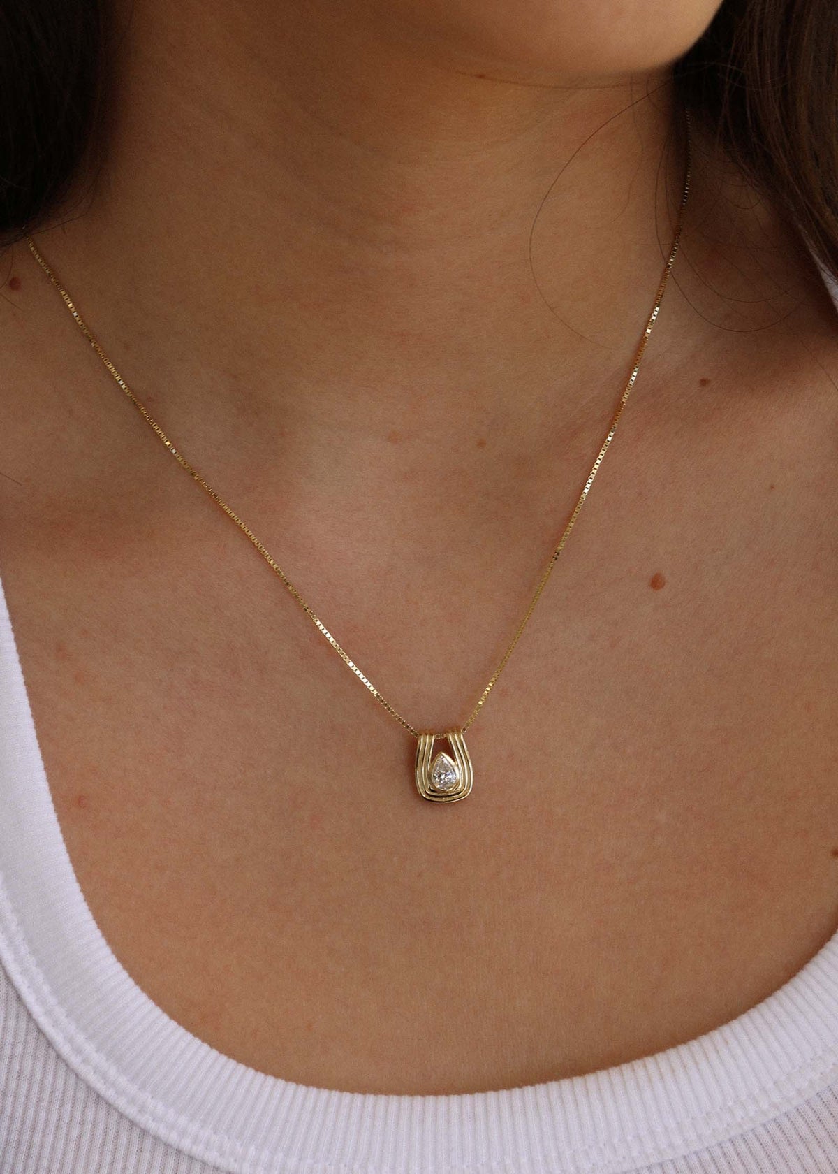 woman wearing a Kinn Studio 14k Gold Alyssa Pear Diamond Pendant on a box chain