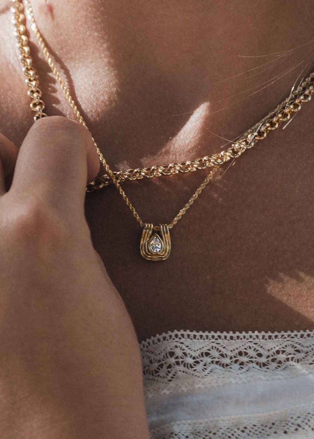 woman wearing a Kinn Studio 14k Gold Alyssa Pear Diamond Pendant on a Petite Rope Chain layered with a Matis Rolo Chain