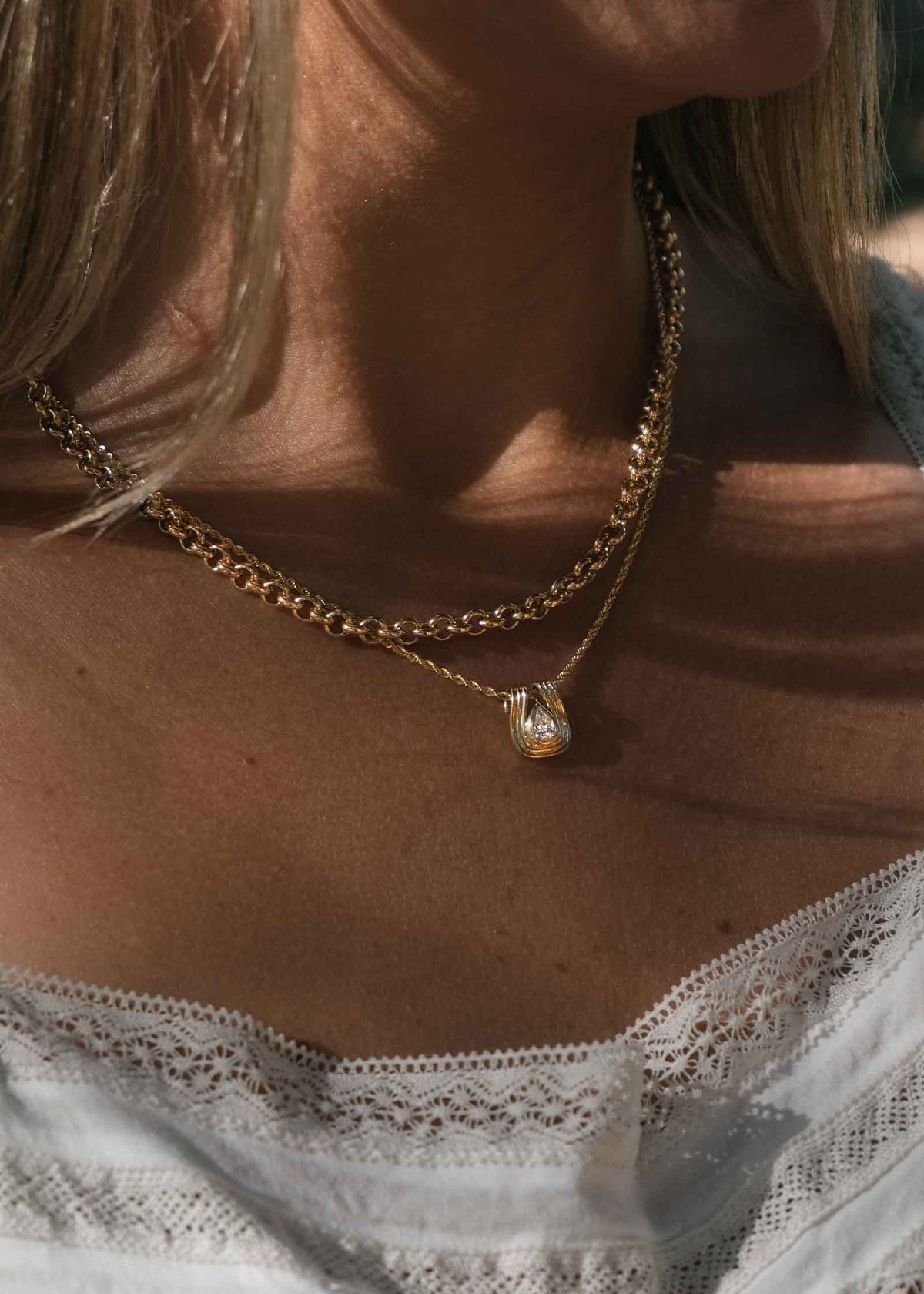 woman wearing a Kinn Studio 14k Gold Alyssa Pear Diamond Pendant on a Petite Rope Chain layered with a Matis Rolo Chain