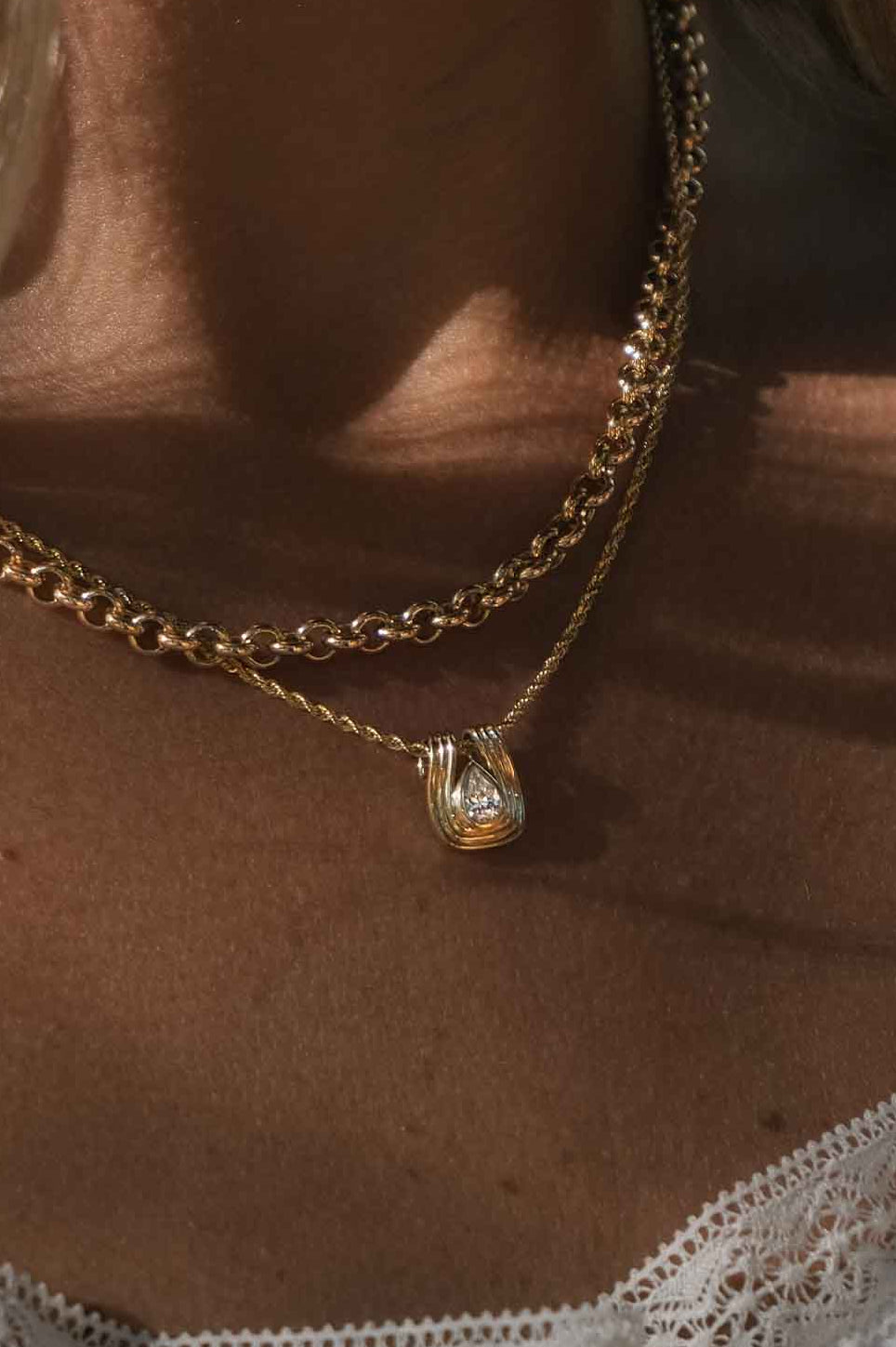 woman wearing a Kinn Studio 14k Gold Alyssa Pear Diamond Pendant on a Petite Rope Chain layered with a Matis Rolo Chain