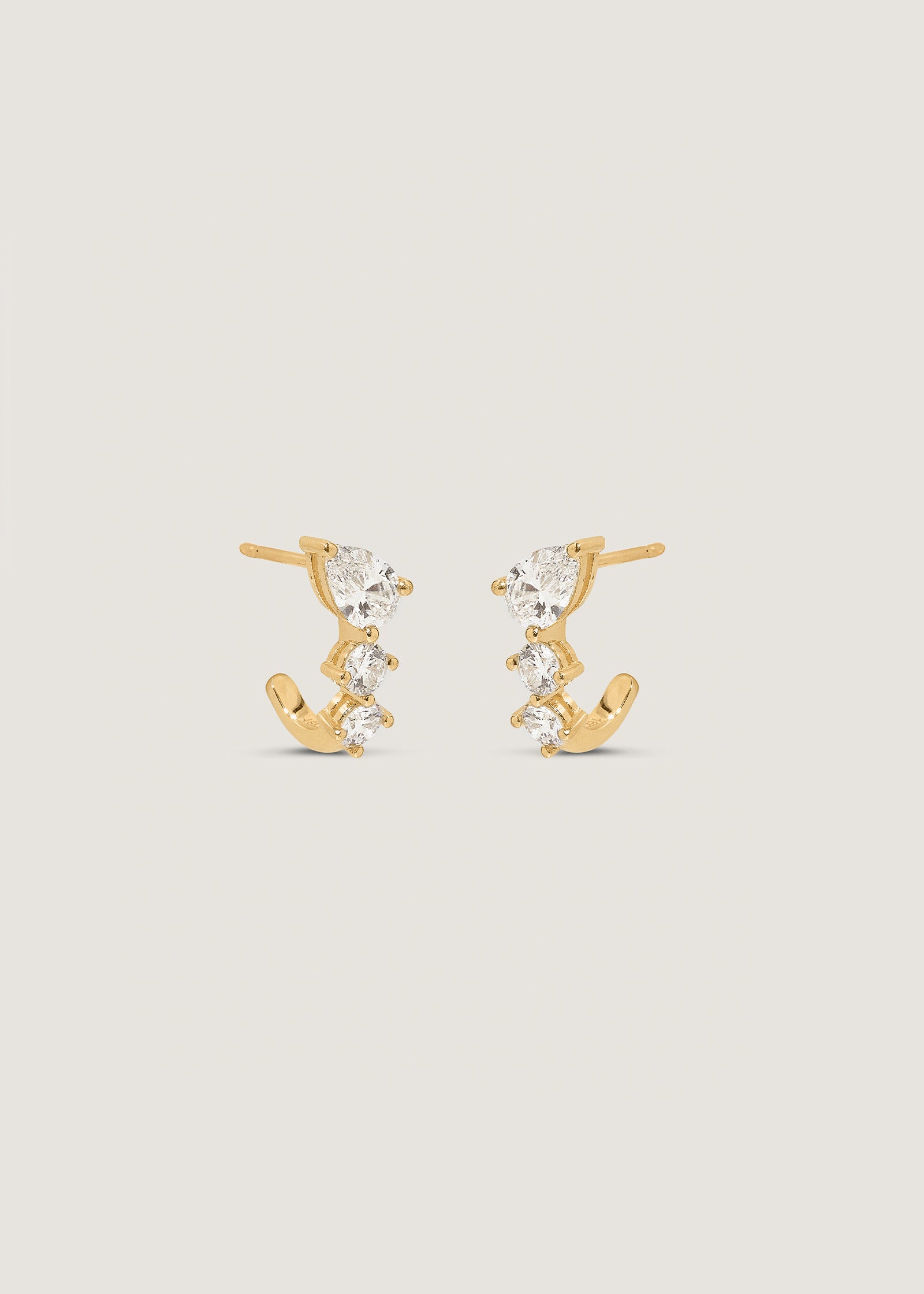 a pair of Kinn 14k Gold Jules Mixed Diamond J-Hoop Earrings angled to the side