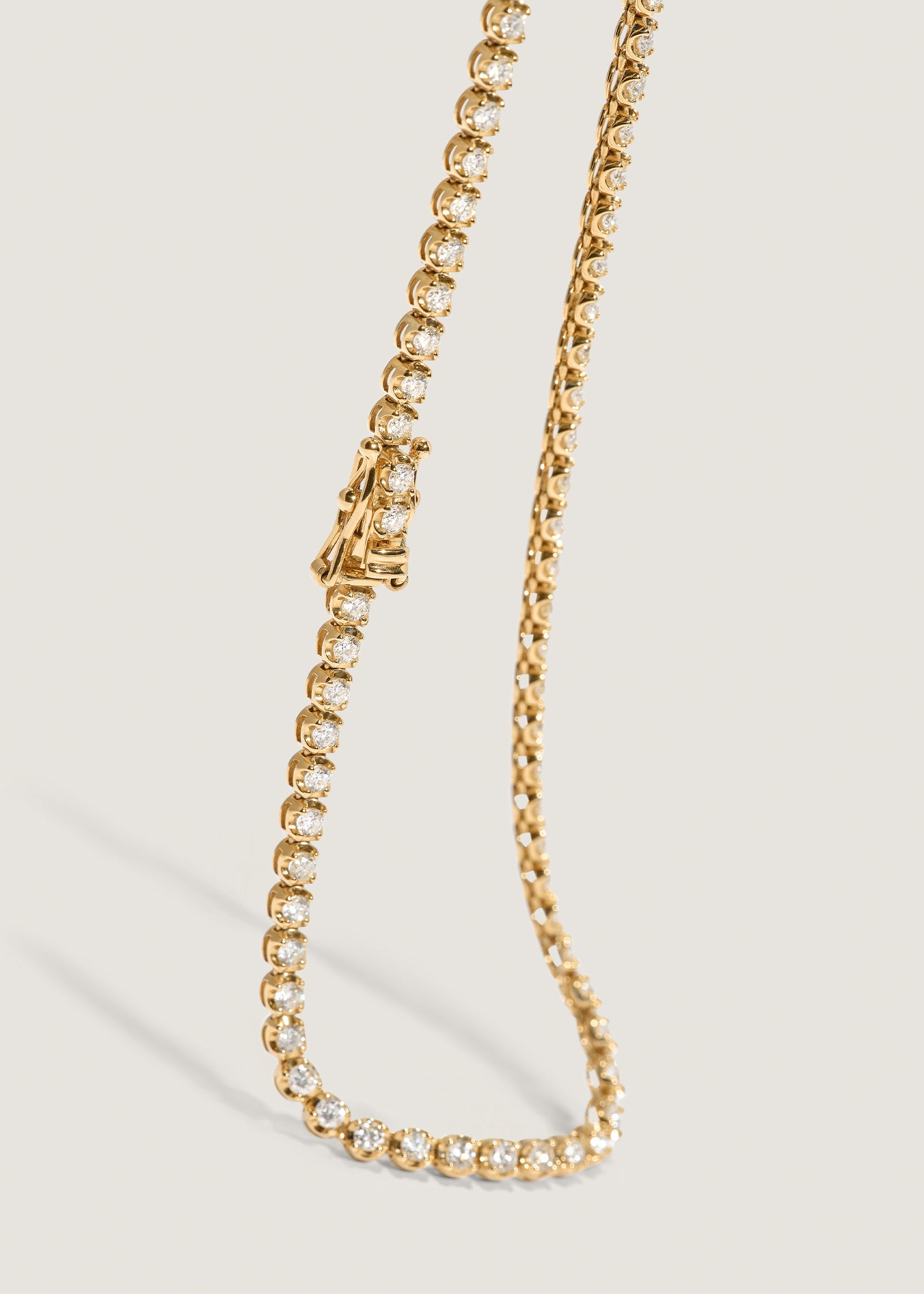 close up of the safety clasp of a Kinn 14k Yellow Gold Madison Diamond Tennis Necklace