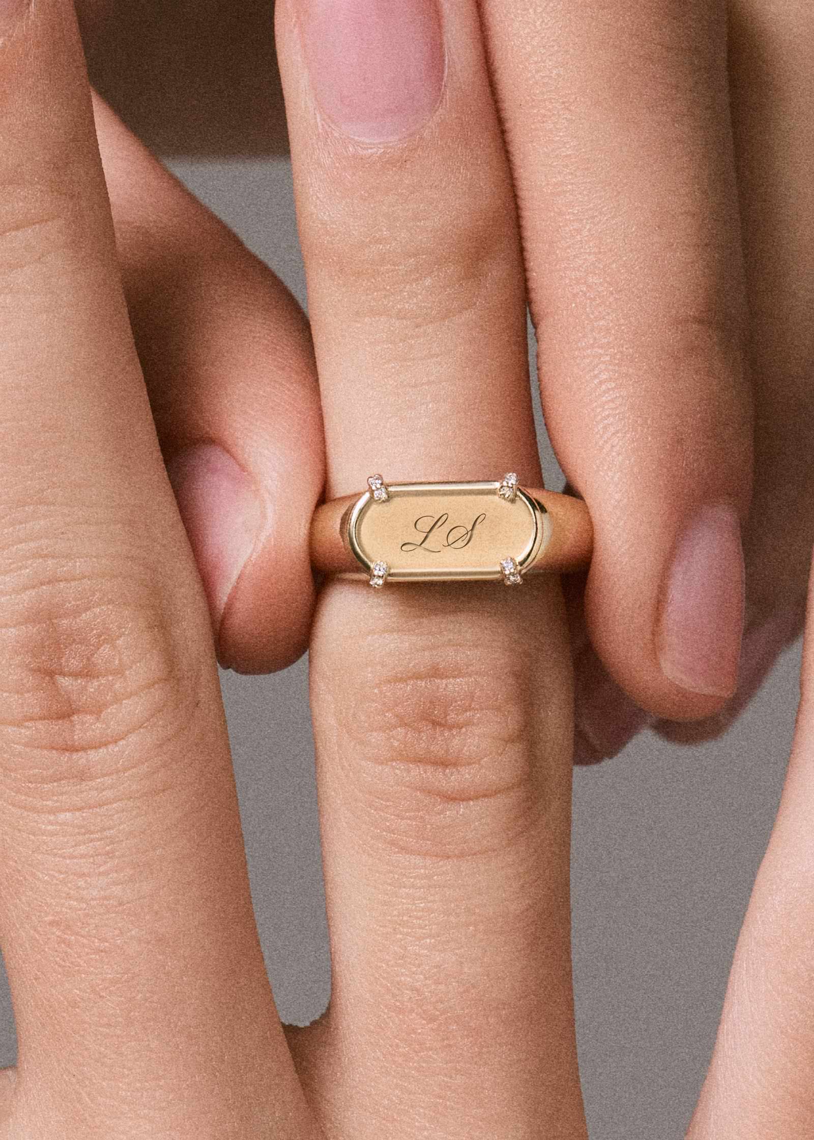 close up of a woman's hand wearing a Kinn 14k gold Harlow Signet Ring Engraved with LS in script font