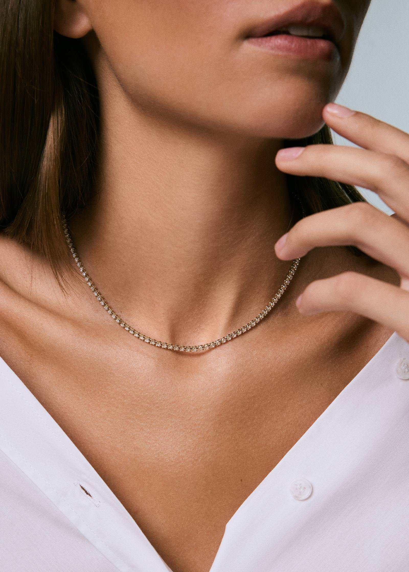 woman in a white shirt wearing a Kinn 14k Yellow Gold Madison Diamond Tennis Necklace