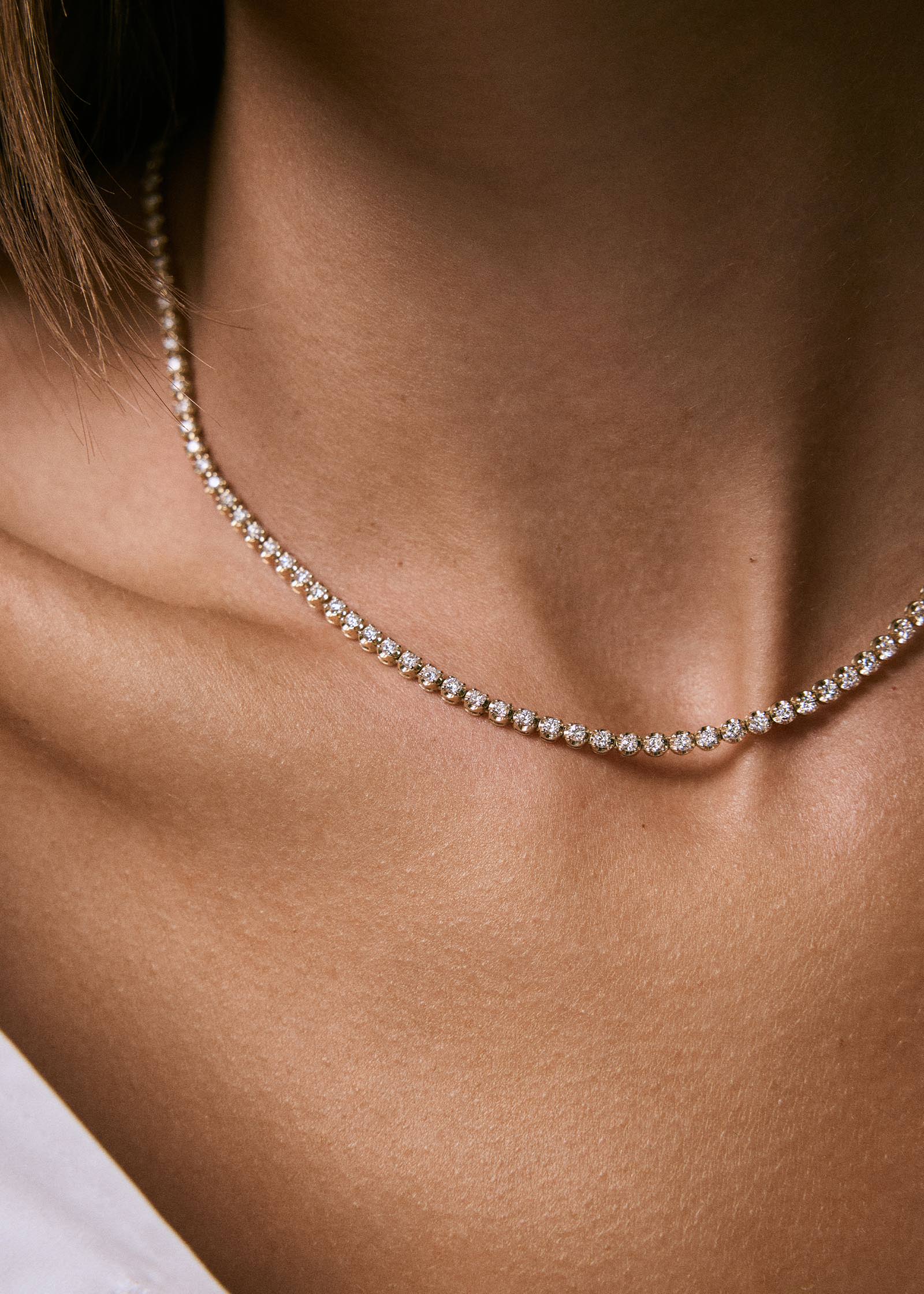 close up of a woman's neck wearing a Kinn 14k Yellow Gold Madison Diamond Tennis Necklace