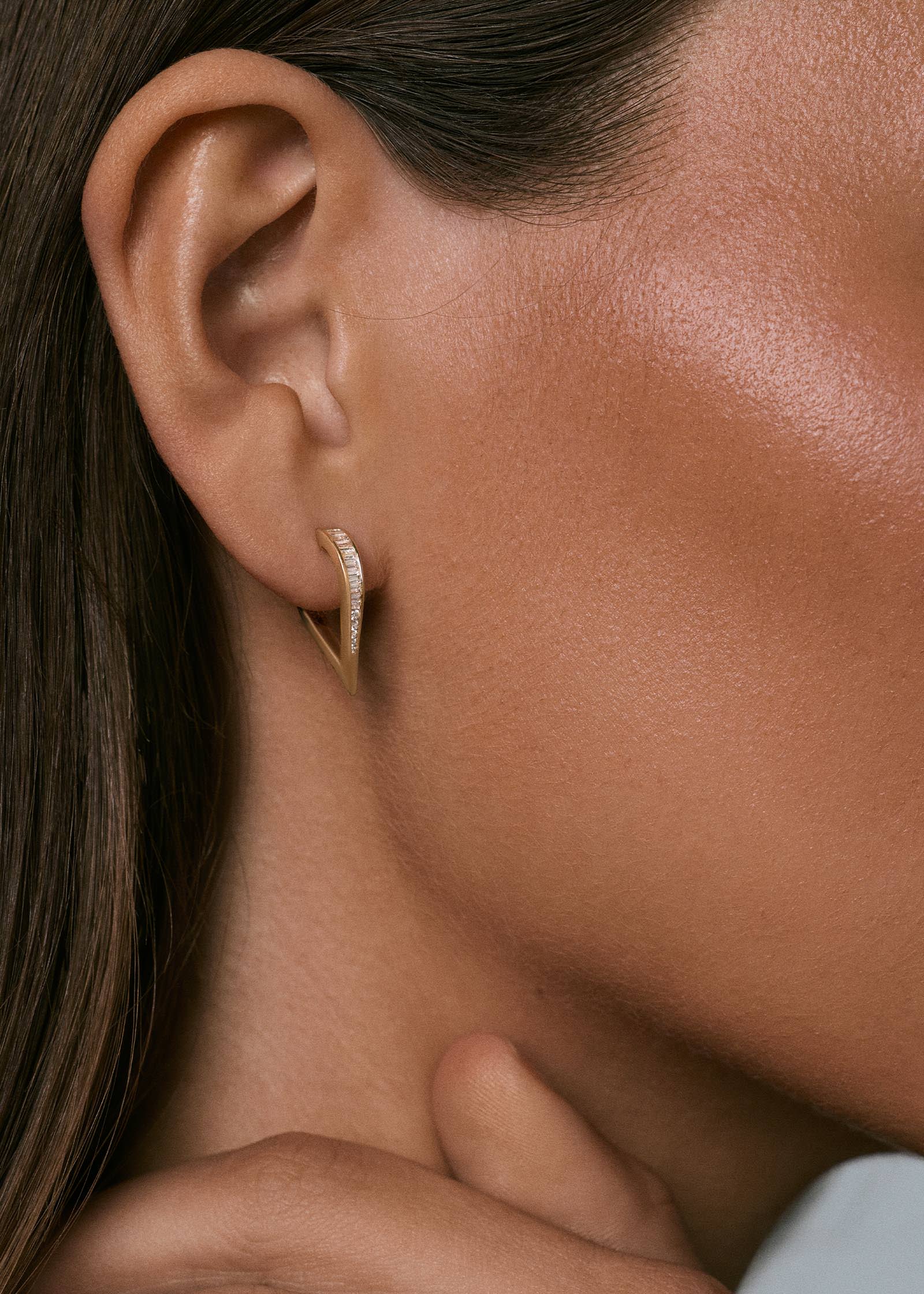 woman's ear wearing a pair of 14k Gold Viola Baguette Diamond Drop Earrings 