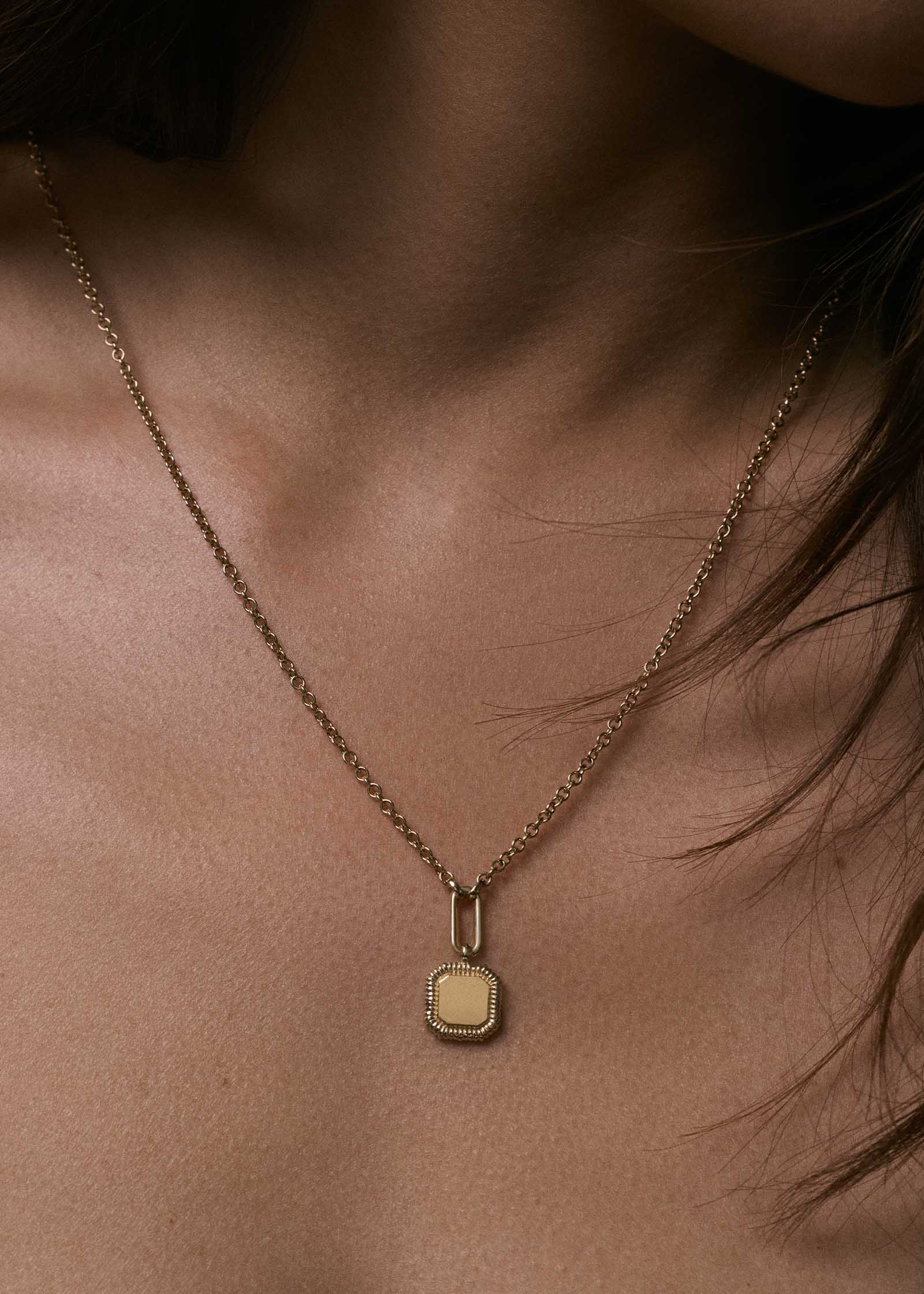 close up of a woman wearing a Kinn 14k Gold Oria Ribbed Octagon Pendant Necklace 