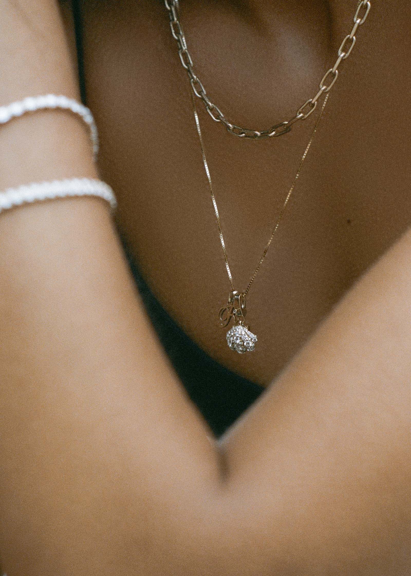 A Kinn 14k Gold Pavé Diamond Shell Charm Pendant and a Love Letter Pendant on a Box Chain Necklace layered with a Mia Link Chain Necklace