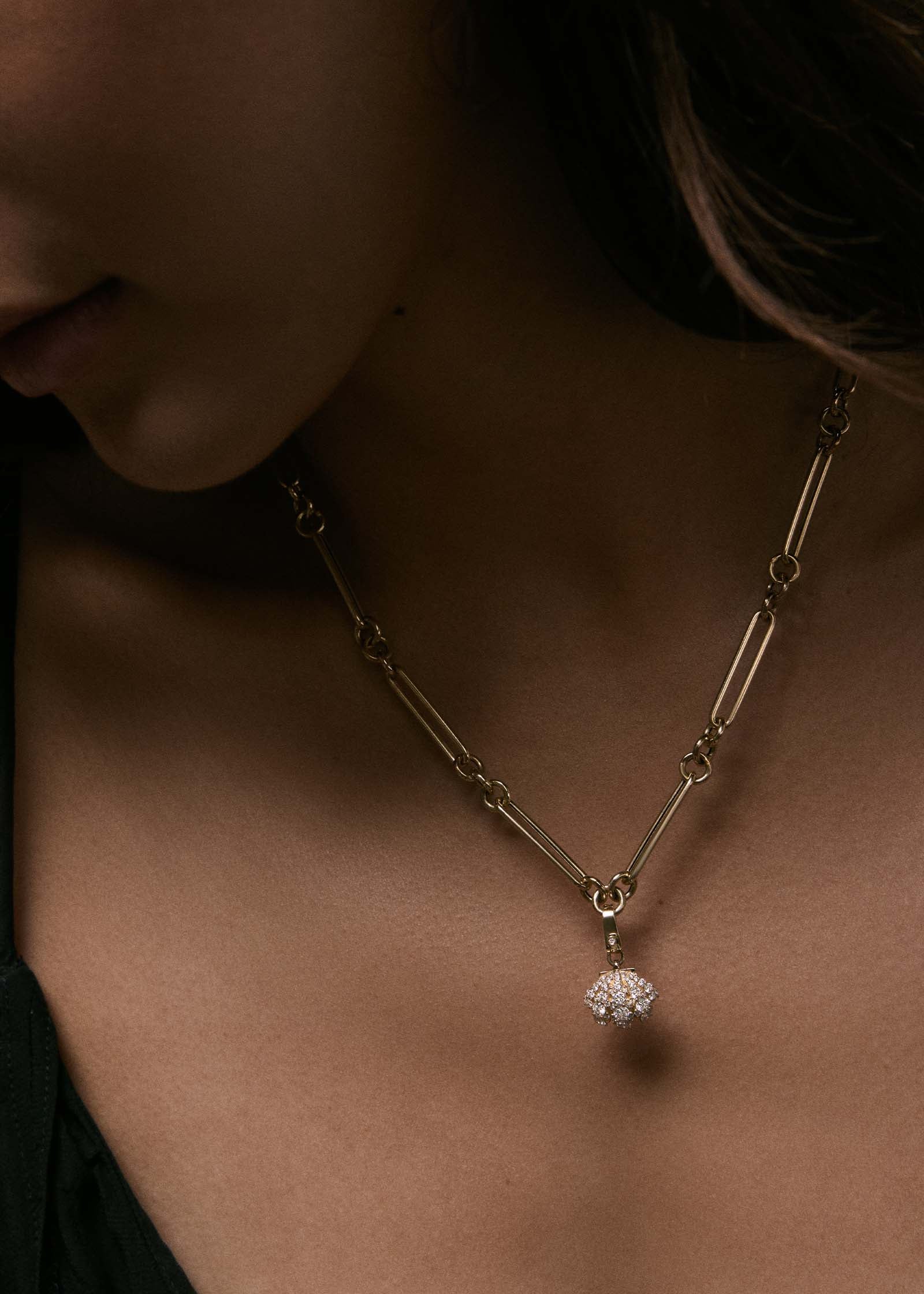 woman wearing a Kinn 14k Gold Pavé Diamond Shell Charm Necklace on Mixed Link Chain