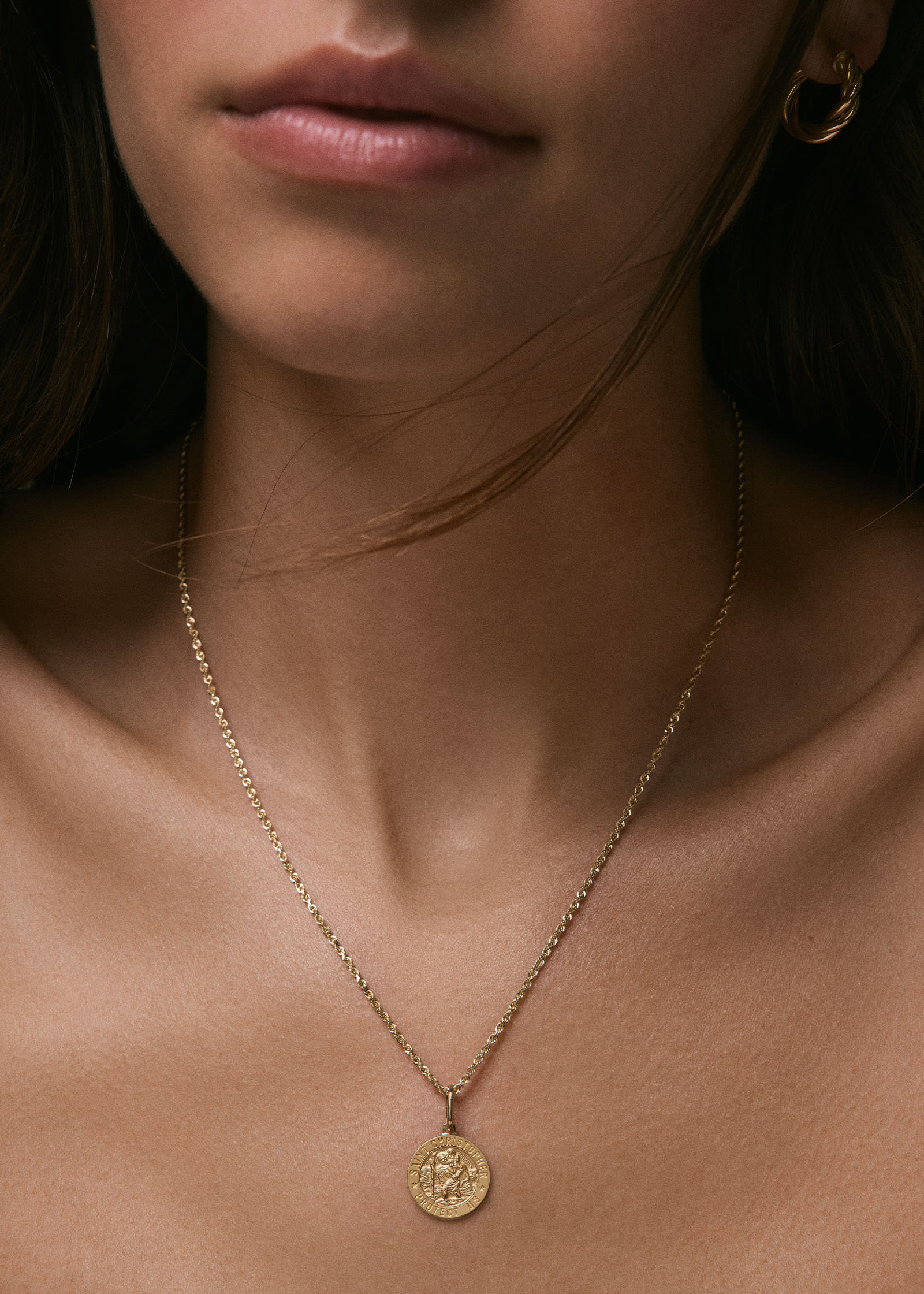 woman wearing a Kinn 14k Gold Saint Christopher Charm Pendant on a Petite Rope Chain