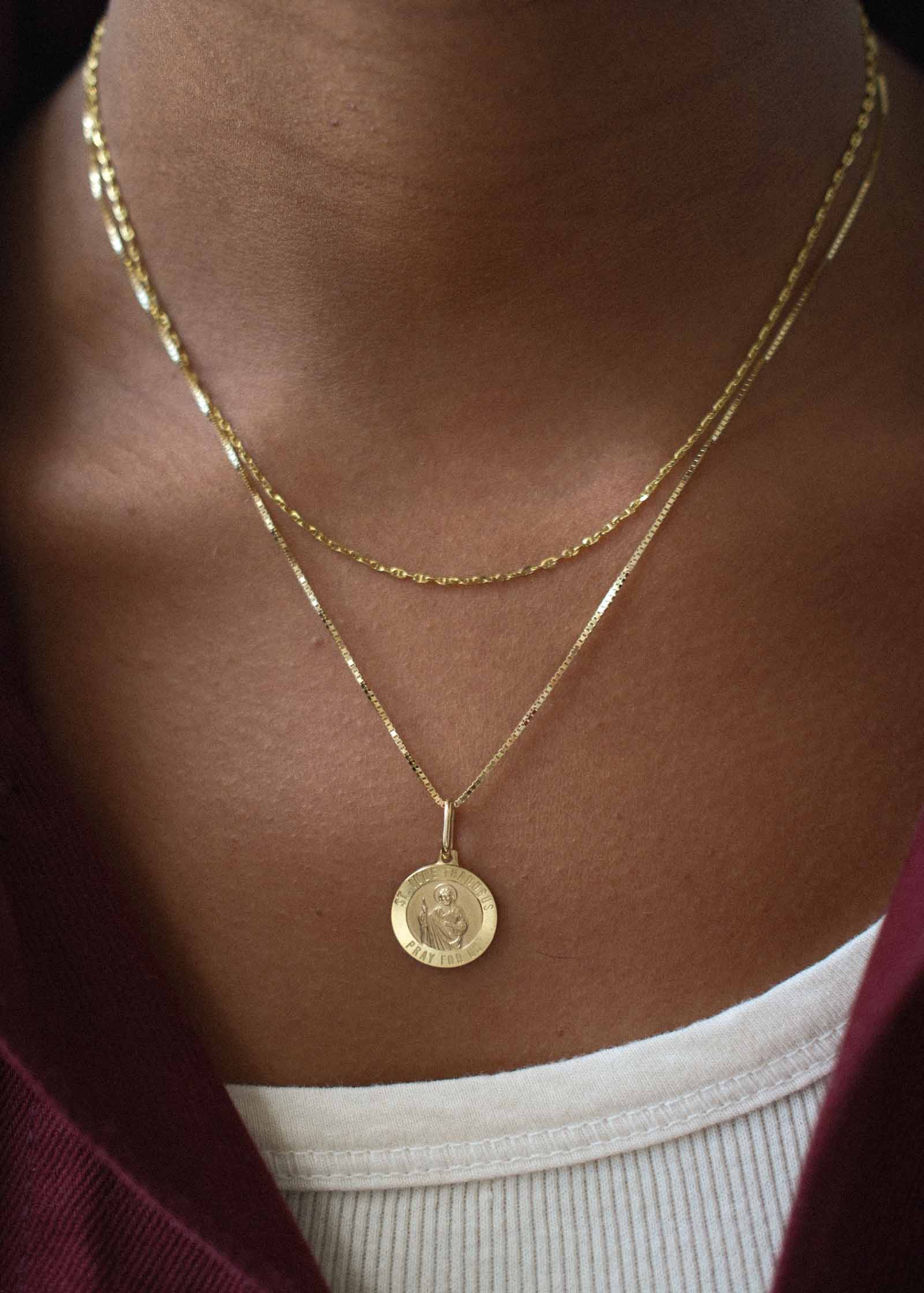 woman wearing a Kinn 14k Gold Saint Jude Charm Pendant on a box chain necklace