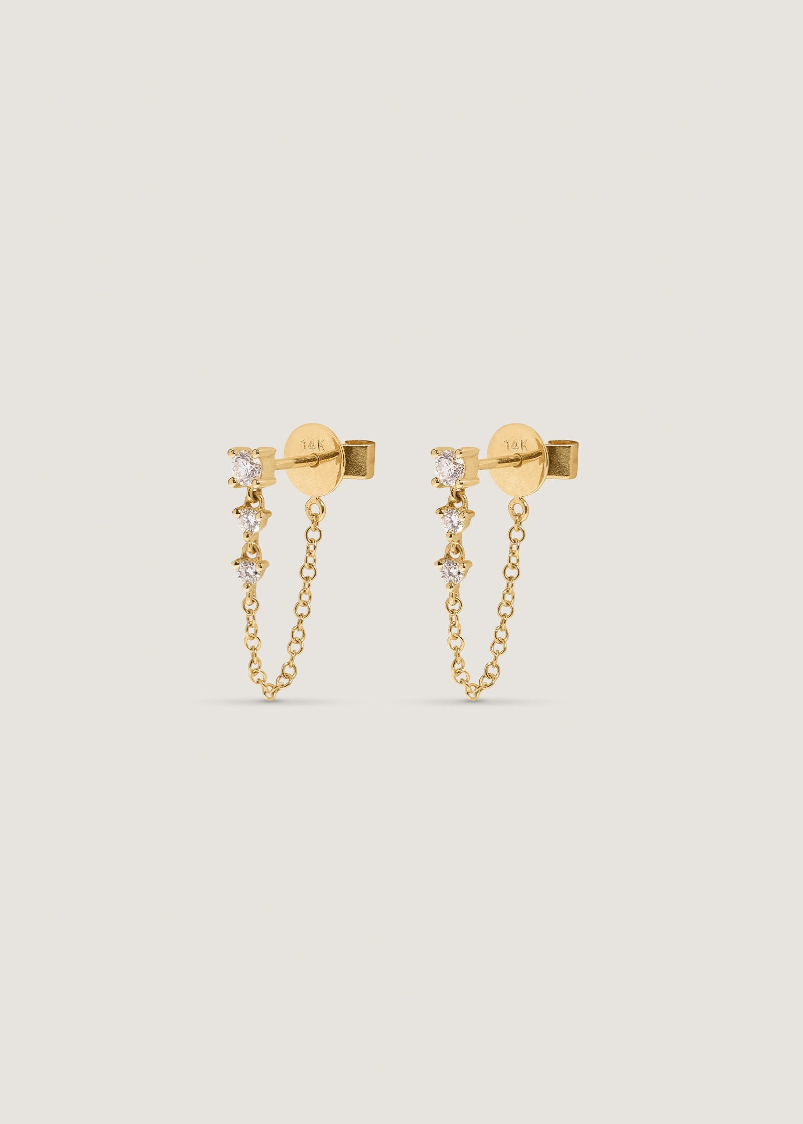 a side view of a pair of Kinn 14k Gold Three Stone Diamond Chain Earrings