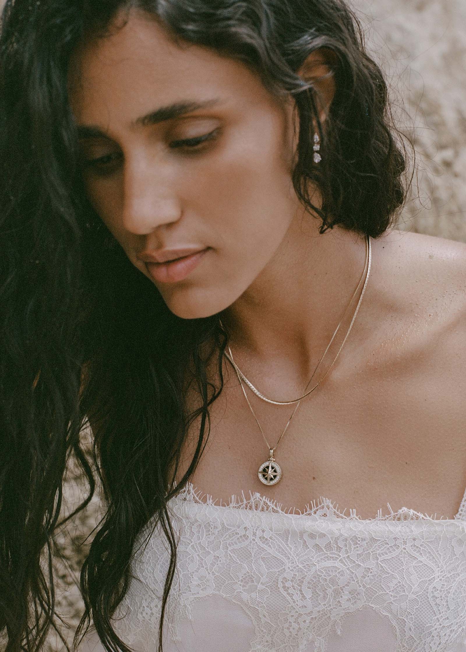 woman wearing a Kinn 14k Gold Vela North Star Pendant on a box chain necklace layered with a Petite Kennedy Herringbone chain