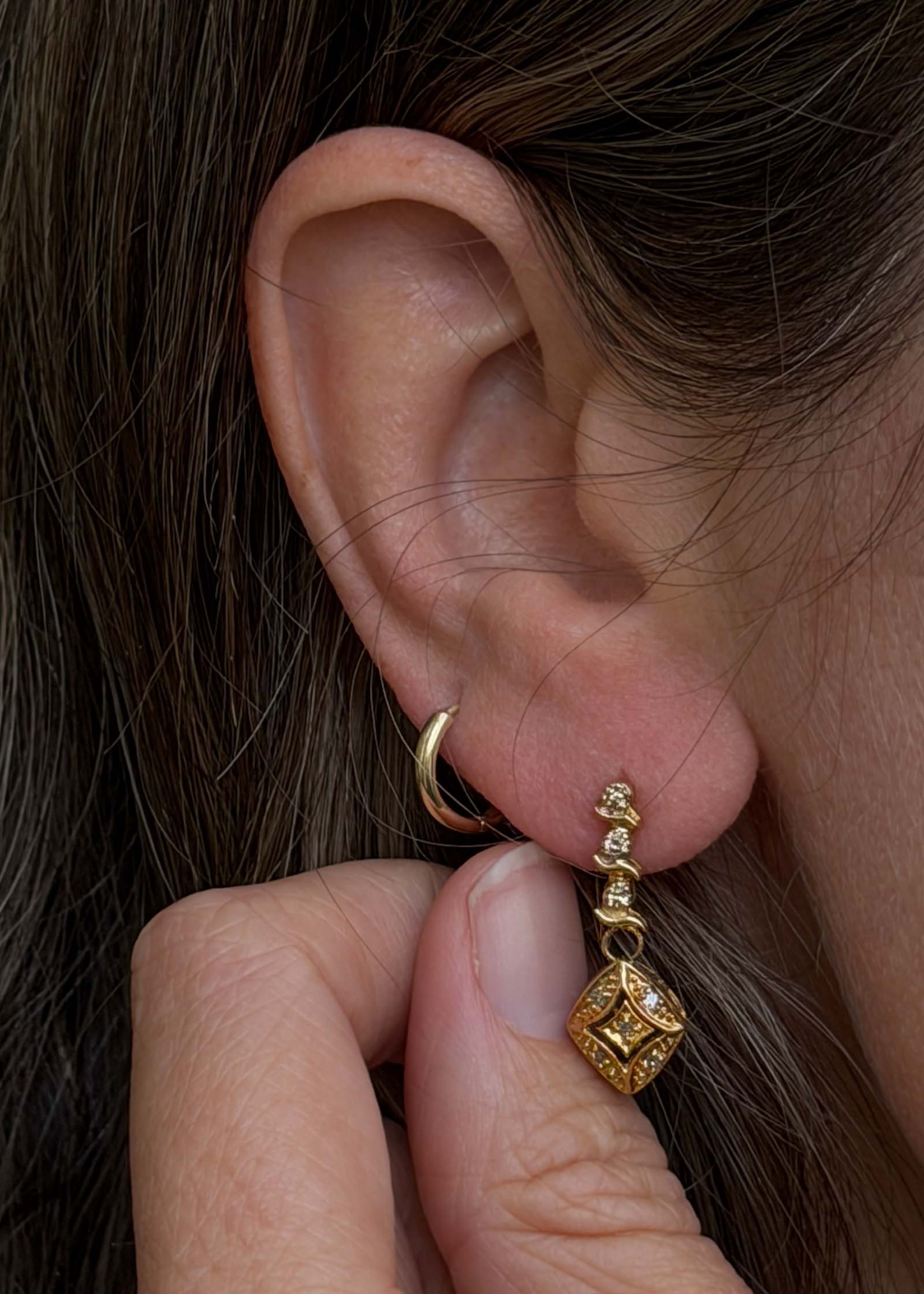 close up of a woman's ear wearing a Kinn Vintage 14k Gold Kite Diamond Dangle Earring