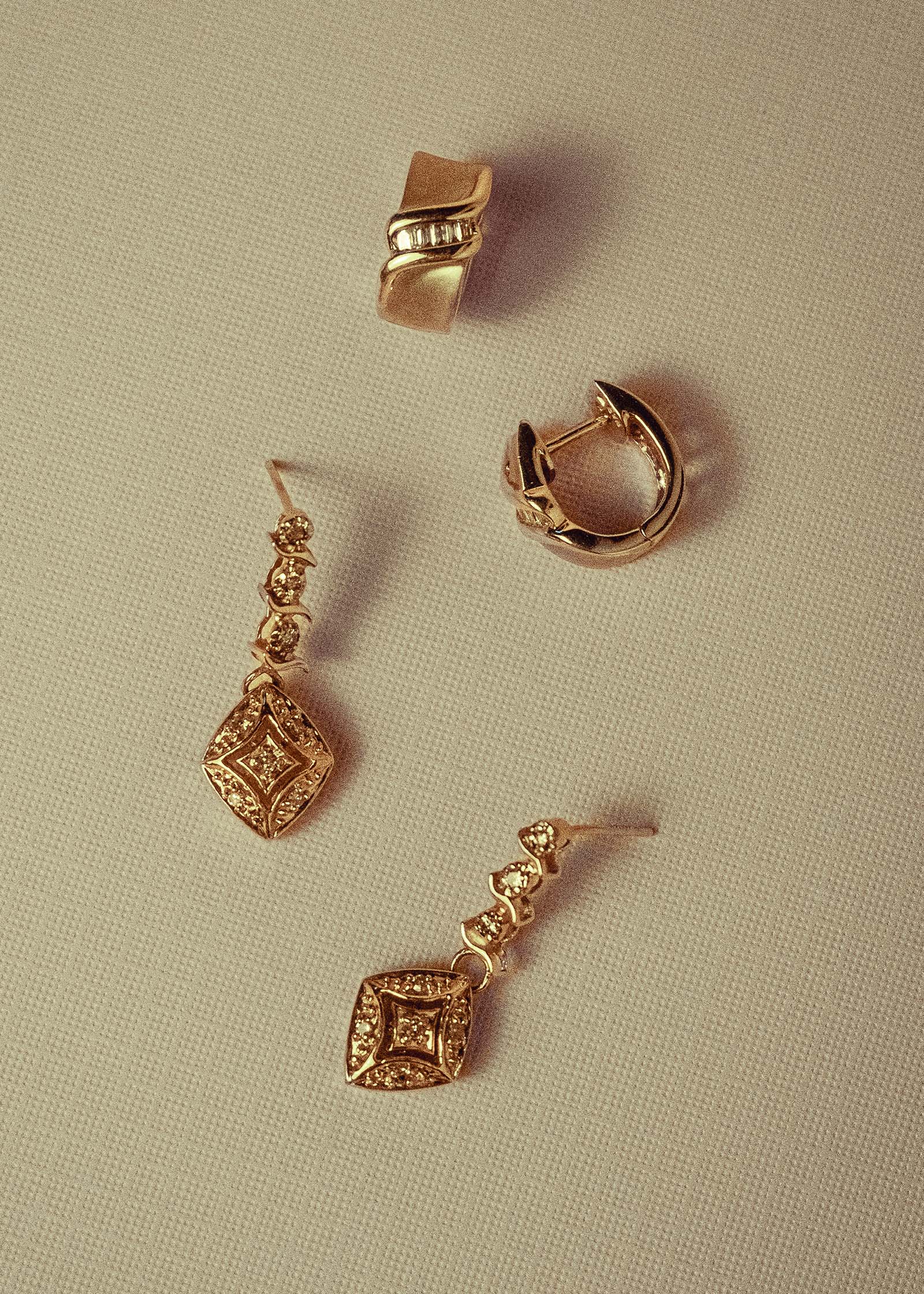 Kinn Vintage 14k Gold Kite Diamond Dangle Earrings laying flat along with a pair of vintage hoops