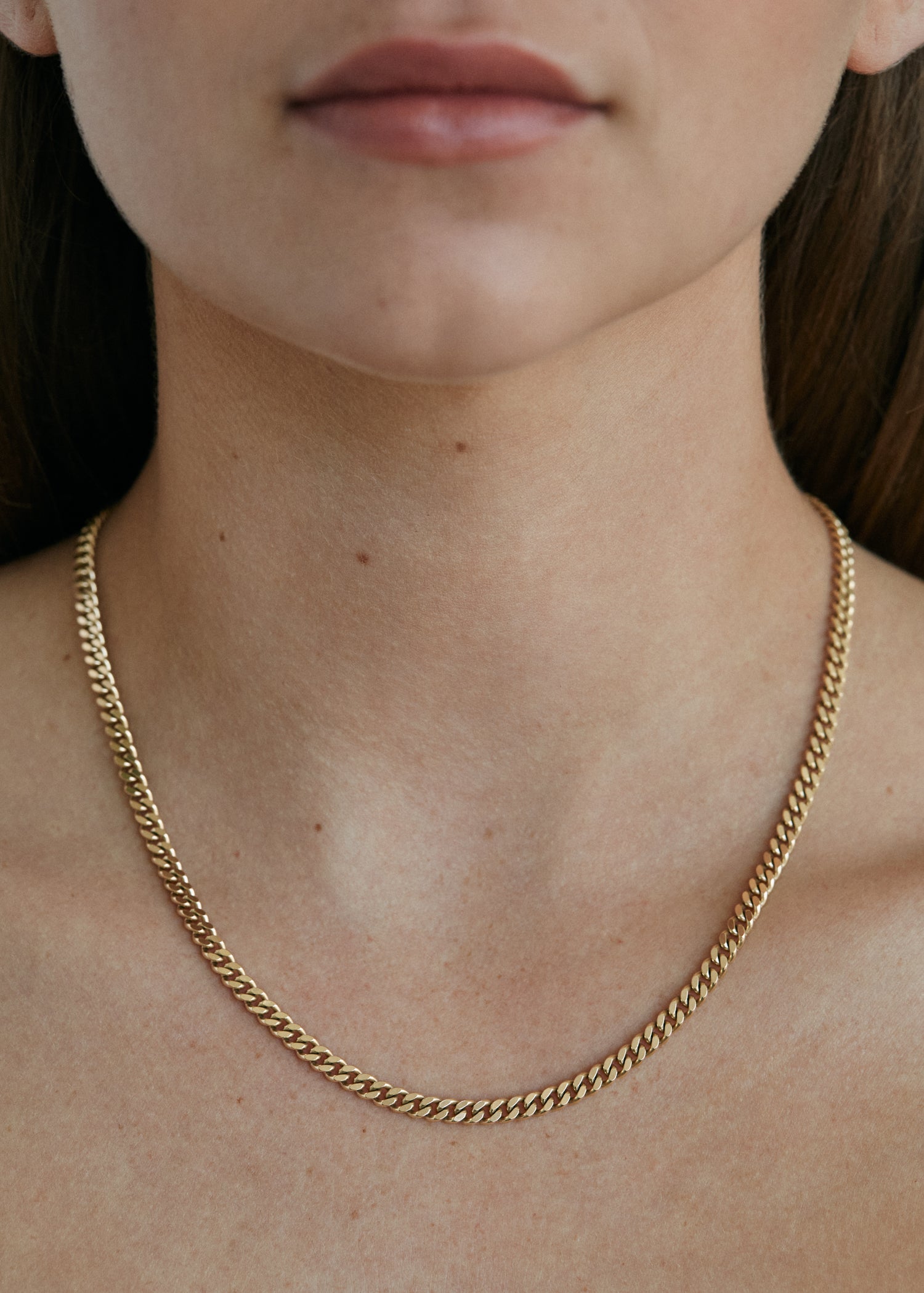 close up of woman wearing a Kinn Studio 14k Gold Capri Curb Chain Necklace